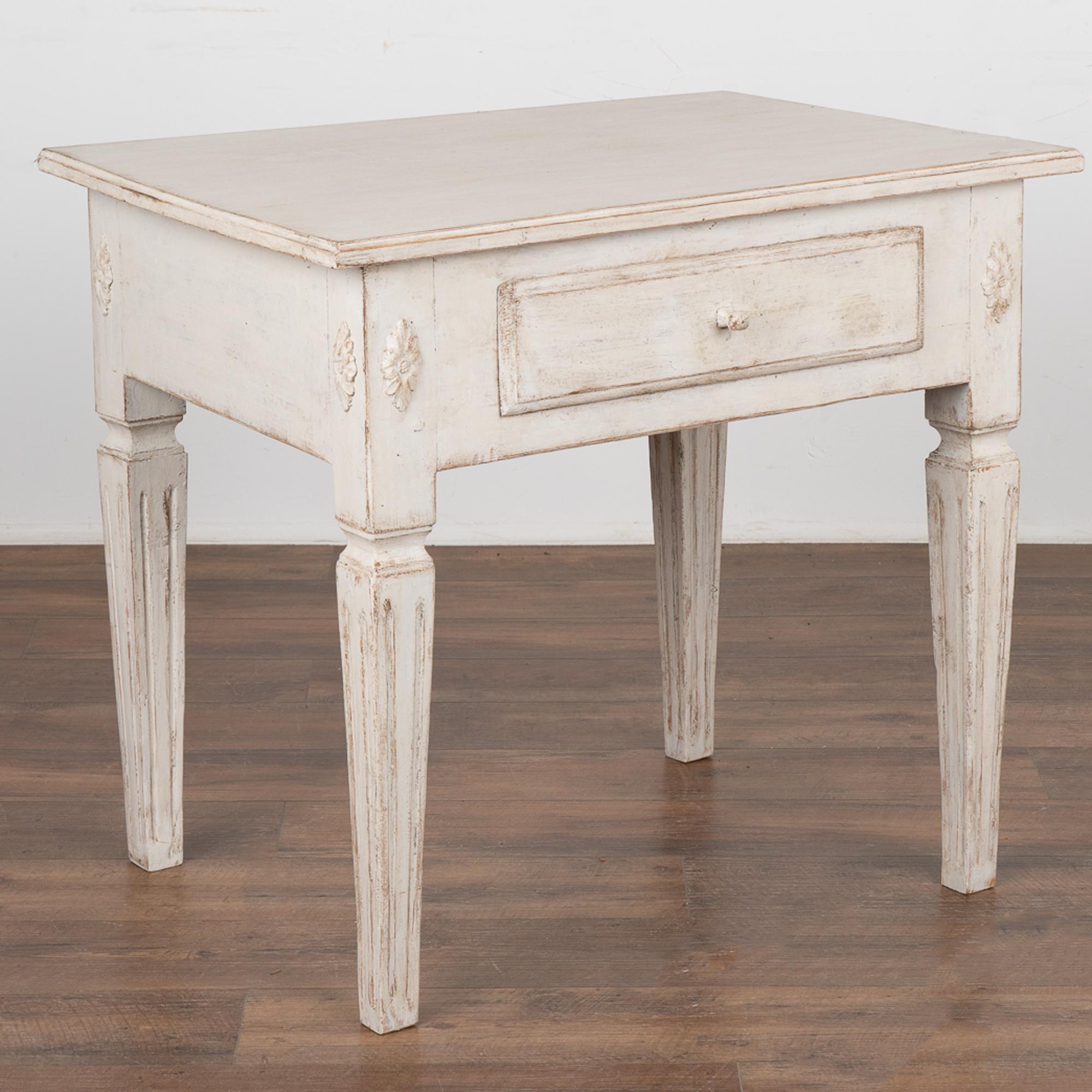 Antique Swedish Gustavian White Painted Side Table With Drawer.
Tapered fluted legs and decorative applied carving accents this useful table. 
Restored, later professionally applied white painted layered finish lightly distressed to fit age and