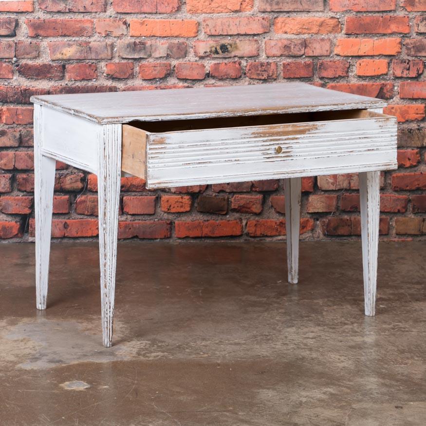 This delightful country Gustavian table with its low stature would make a great side table or nightstand. The table has an off white painted finish, which has been gently distressed matching it's age and character. The wax finish enhances the paint