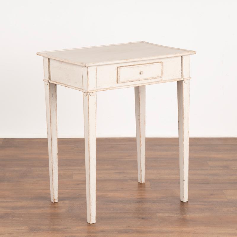 This delightful country Gustavian table will make a lovely side table or nightstand. The table has a newer, professionally applied layered white painted finish which has been gently distressed matching it's age and character. Note the lovely tapered