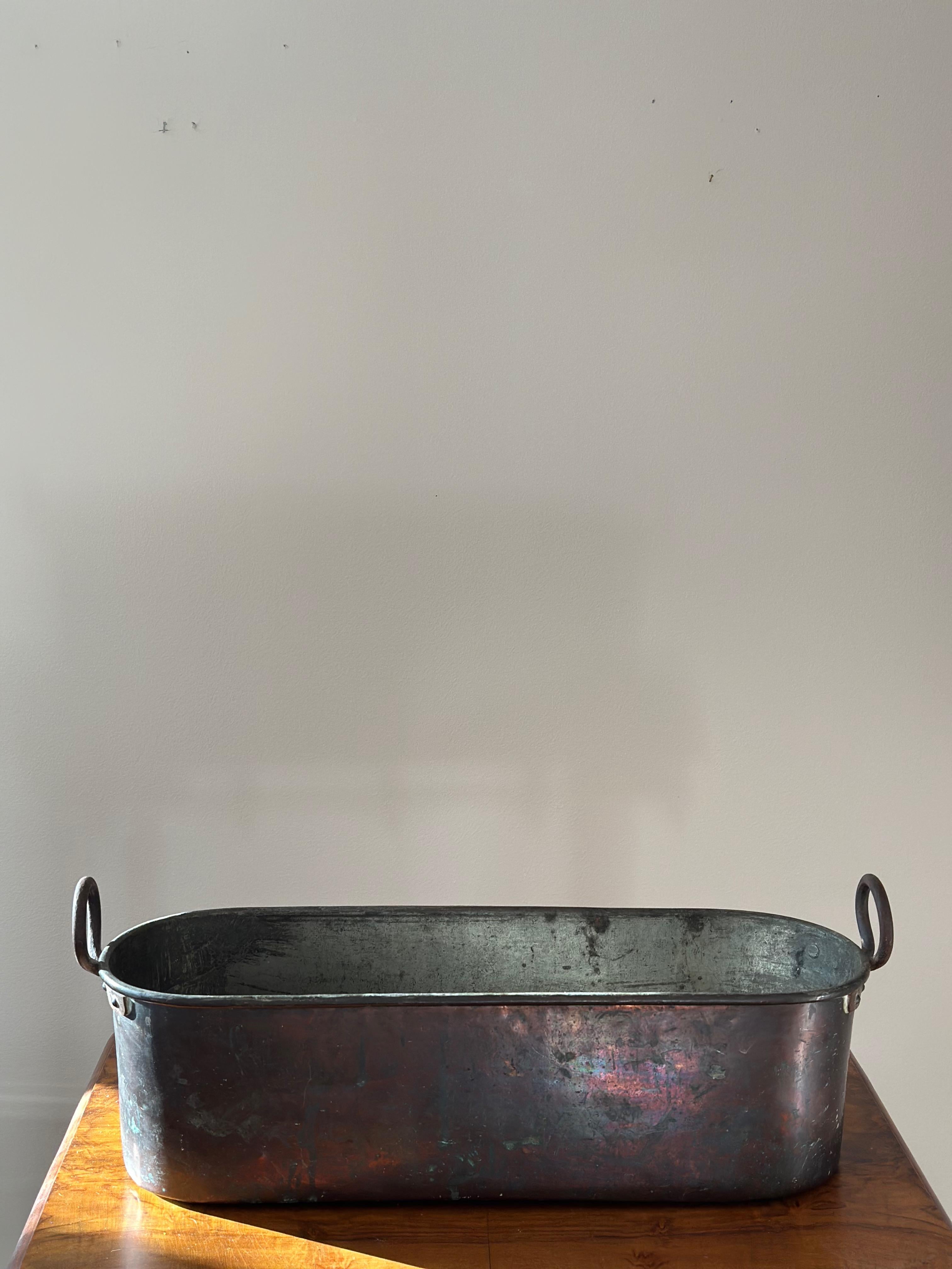 Jardinière en cuivre martelé suédoise du début du 20e siècle avec poignées en fer. Cette jardinière robuste était à l'origine une poêle à poisson ou une poissonière.
Il mesure 22
