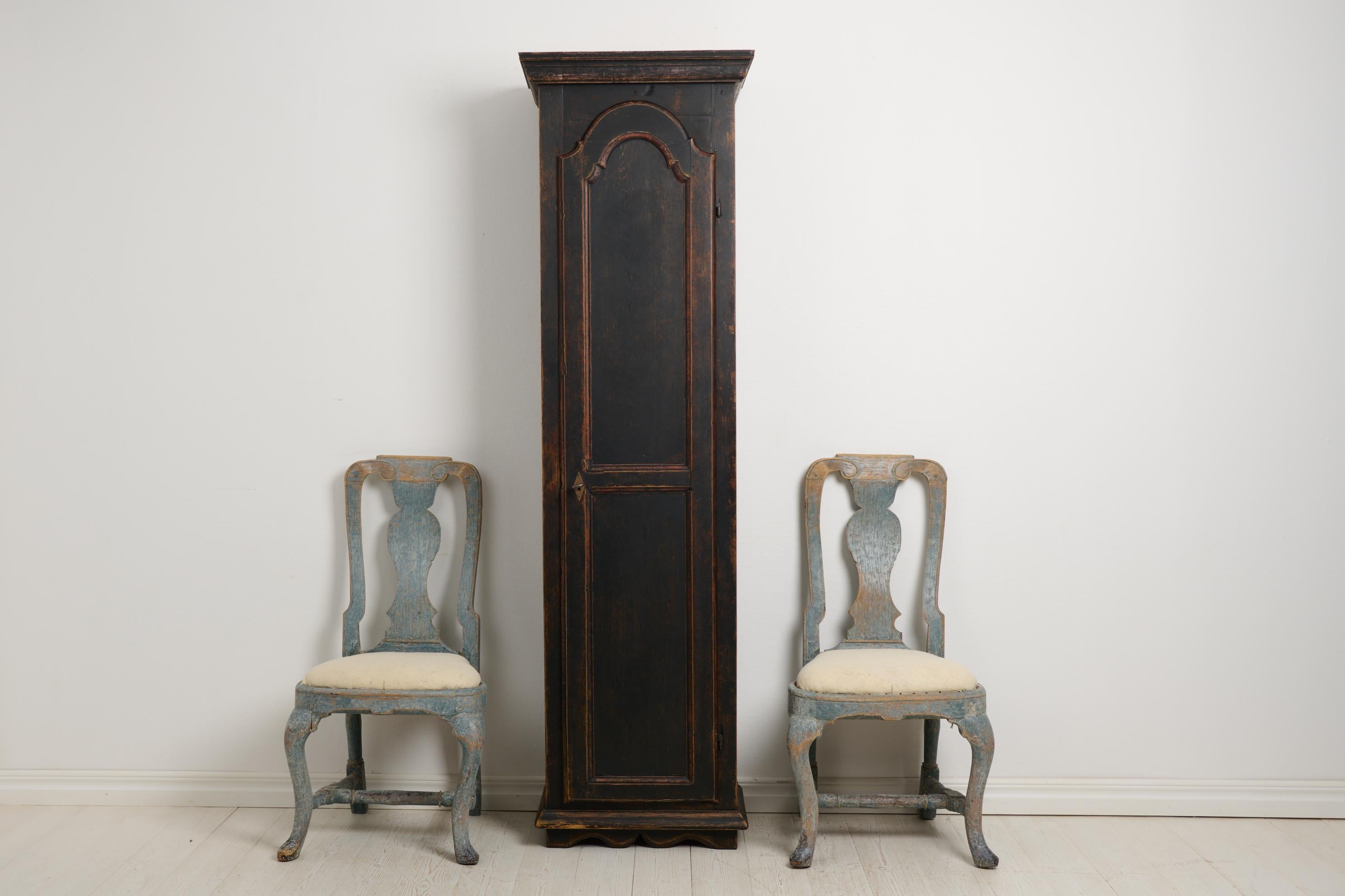 Antique Swedish narrow cabinet with a single door. The cabinet has an unusual shape, tall and narrow. Made by hand in northern Sweden around the 1840s. The frame is solid pine and the interior has shelves and cubbies. The inside has never been