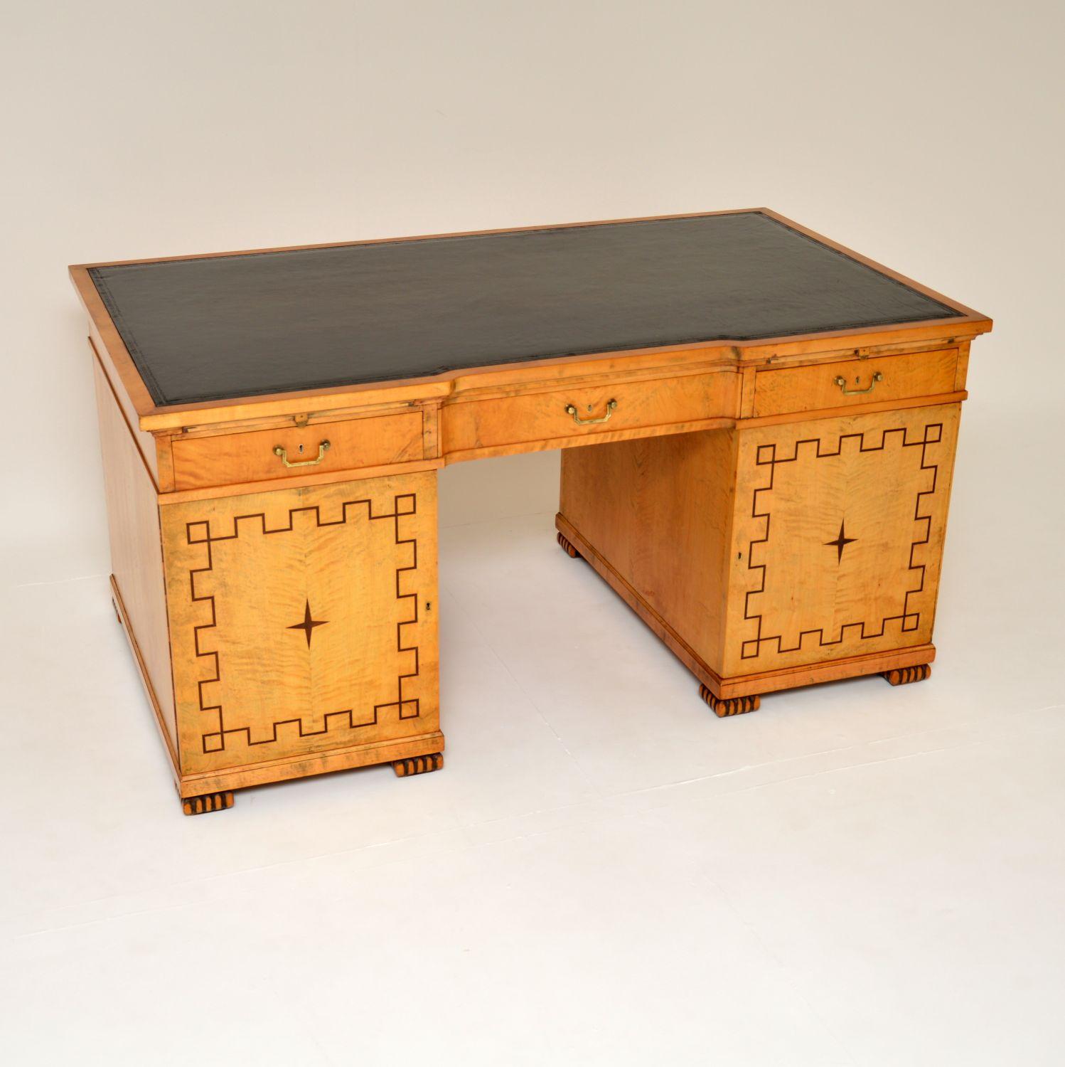 A magnificent antique satin birch Biedermeier leather top desk of the highest order. This was made in Sweden, it dates from around the 1880-1900 period.

It has a strong neoclassical influence, with lovely geometric patterns on the front and back of