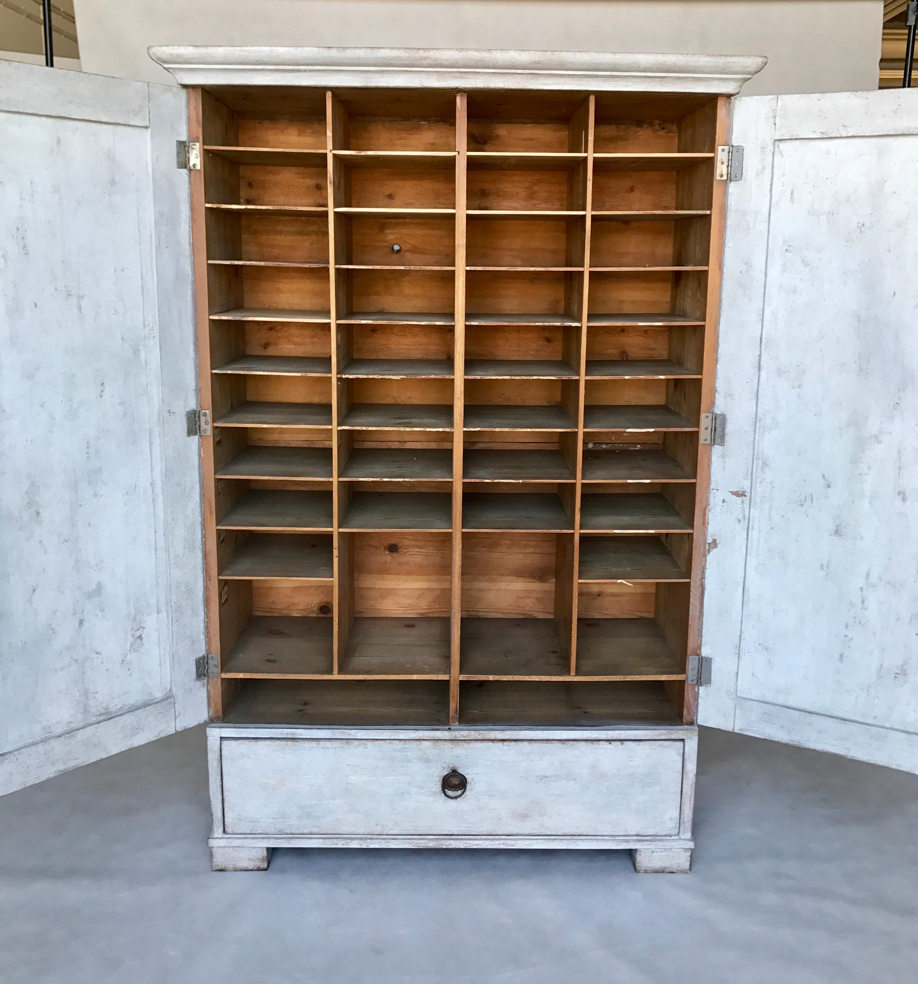 The office cabinet of the Skane from Sweden. The piece has many small shelfs inside. It is a great work organizer. There is one large drawer in the lower part of the cabinet. The furniture has original fittings and locks.
Exterior color light gray.