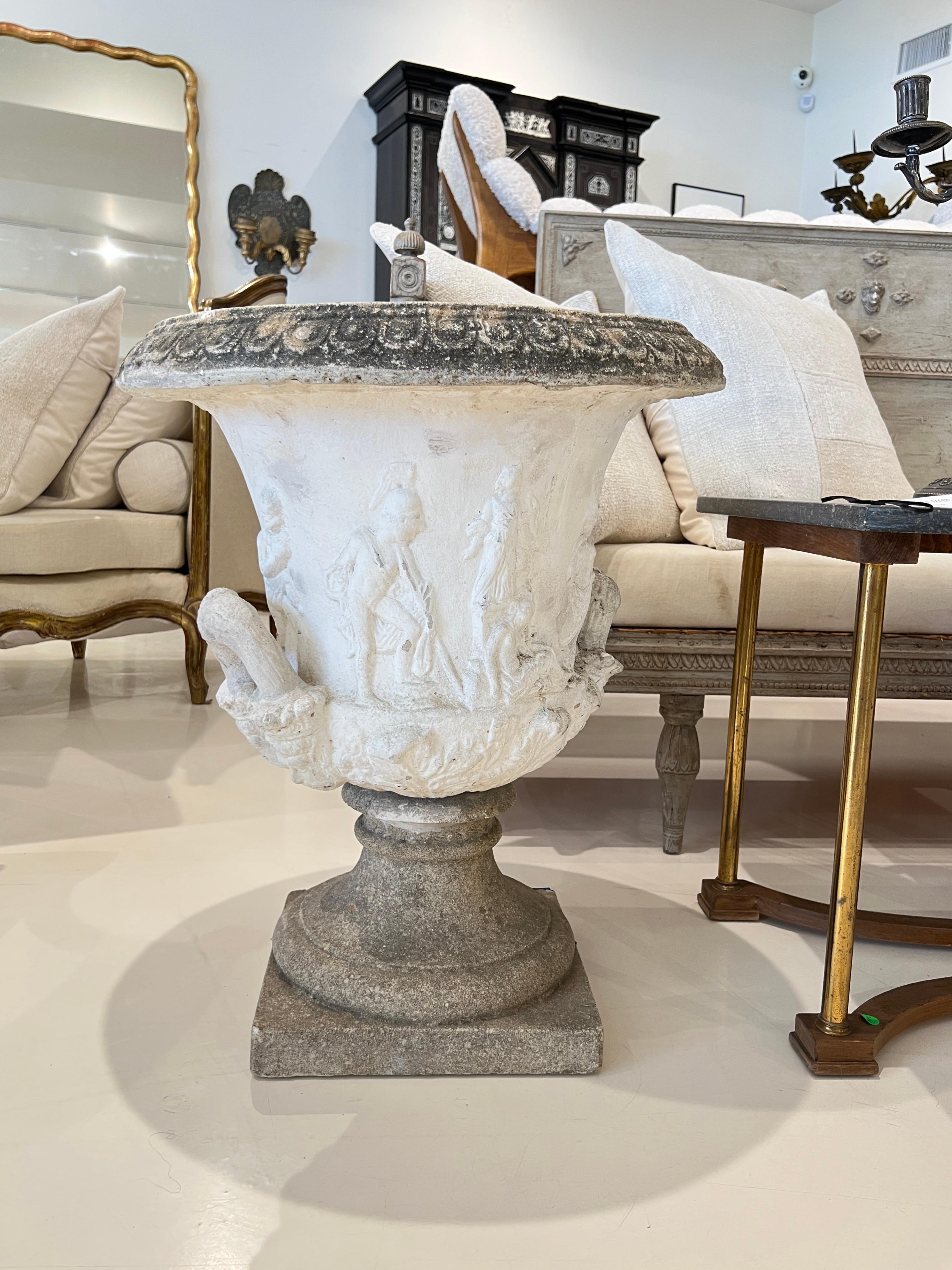Un escultural par de jardineras suecas inspiradas en el emblemático Jarrón Borghese, con formas de urna clásica con intrincados relieves moldeados y un acabado desgastado que combina la grandeza neoclásica con la sobriedad escandinava.