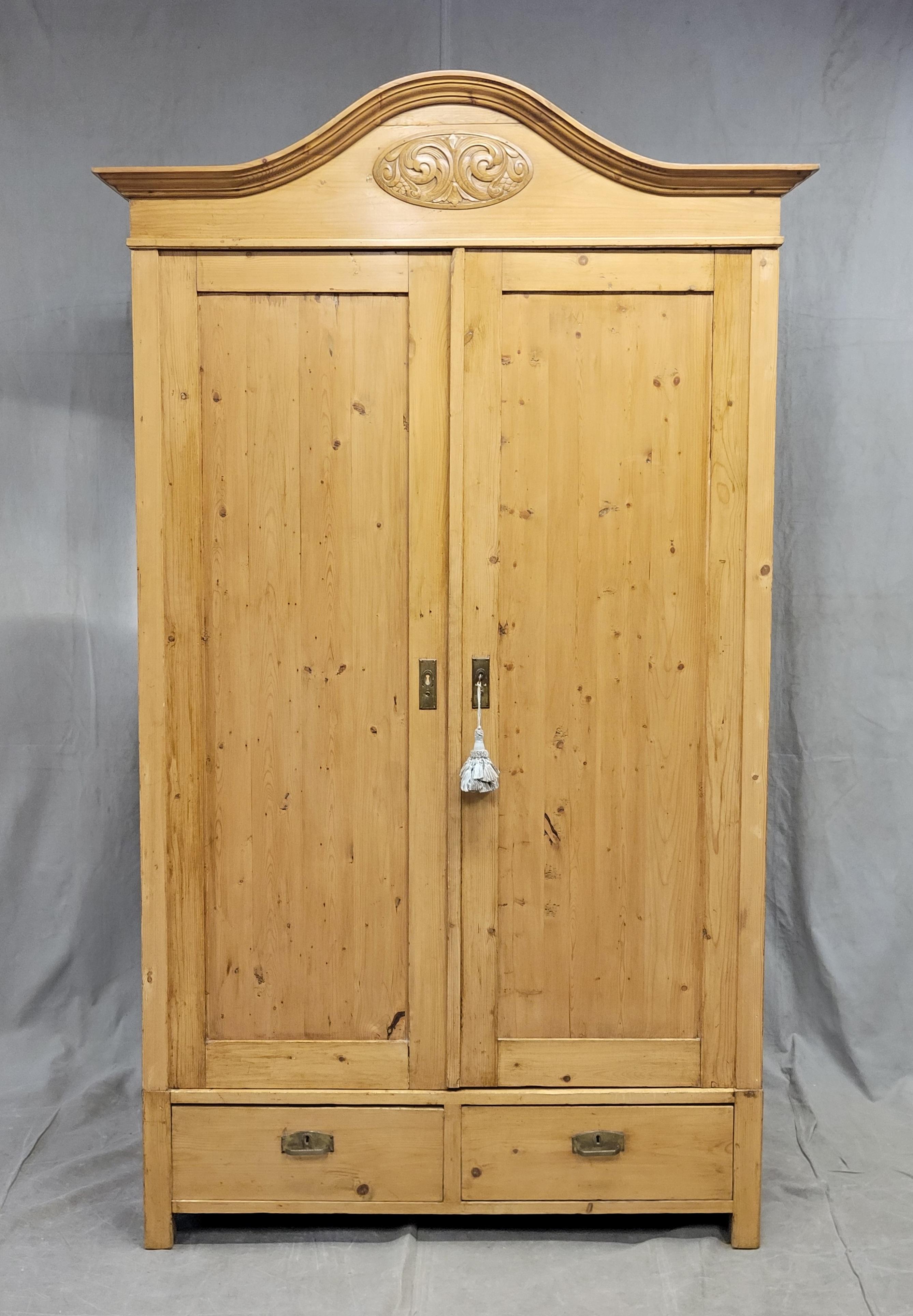 A beautiful antique early 1900s Swedish waxed pine divided armoire with six shelves and two drawers. Original brass hardware with working key that locks the doors. A beautiful and functional antique piece that offers a large amount of