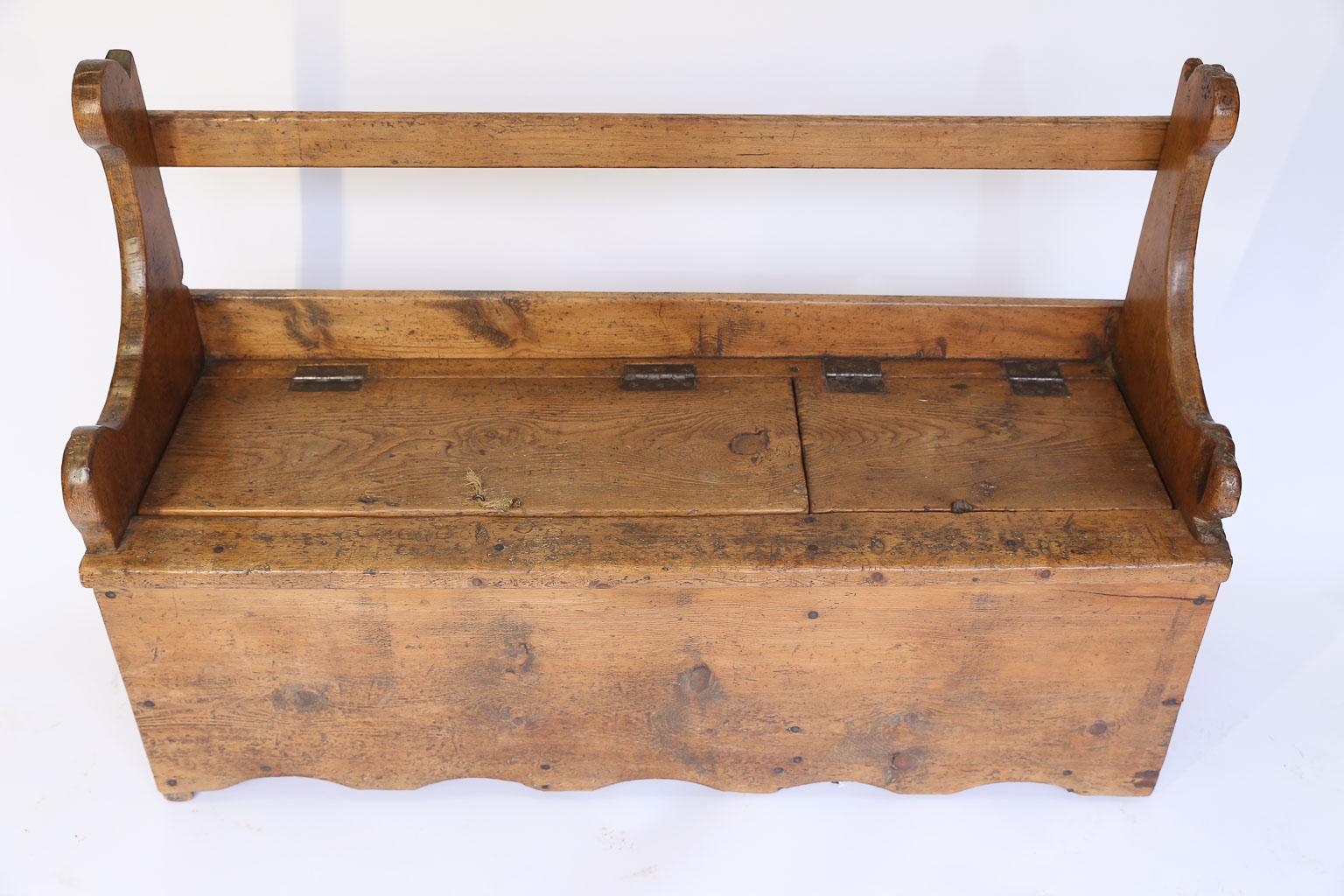 This is a beautiful pine Swedish bench handcrafted in the late 1800s. The waxed patina and minimal decoration enhance the rustic charm of this wonderful piece while the seat lifts on iron hinges in two places to allow storage. The piece is solid and