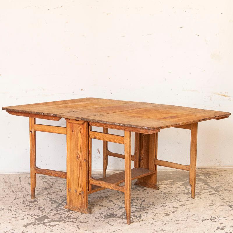 It is the wonderful worn pine that has taken on a deeper patina through years of use that draws one to this gate leg table from the Swedish countryside. Notice old stains, rings, scratches, water marks etc that reflect the generations who have sat,