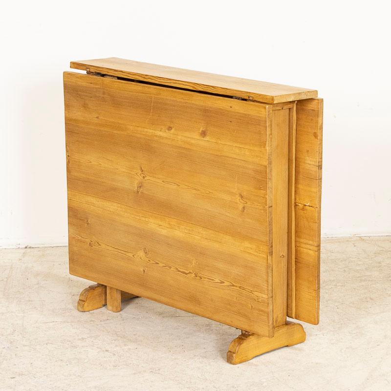 It is the wonderful warm pine that draws one to this gate leg table from the Swedish countryside. Any nicks, scratches, and small cracks reflect the generations who have sat, dined, worked and conversed over this table. The drop leaf feature allows