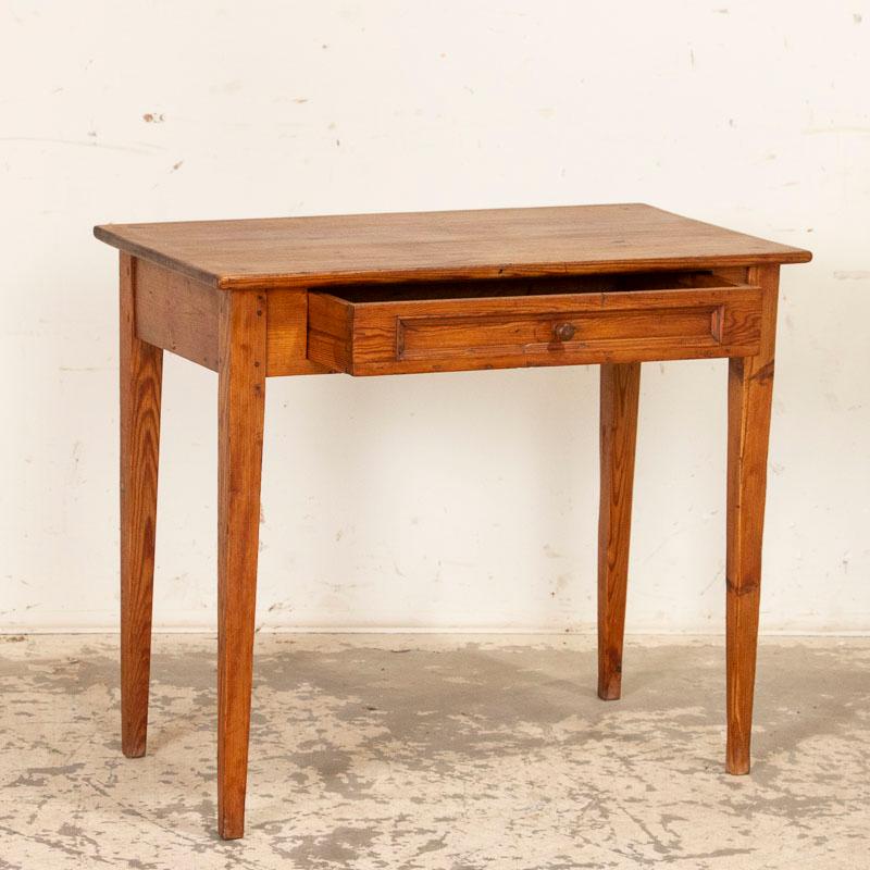 The endearing quality of this Swedish side table comes from the simple lines, tapered legs and lovely warm patina of the pine which has aged and deepened gracefully through many generations. Note the dovetail joints and single drawer which runs