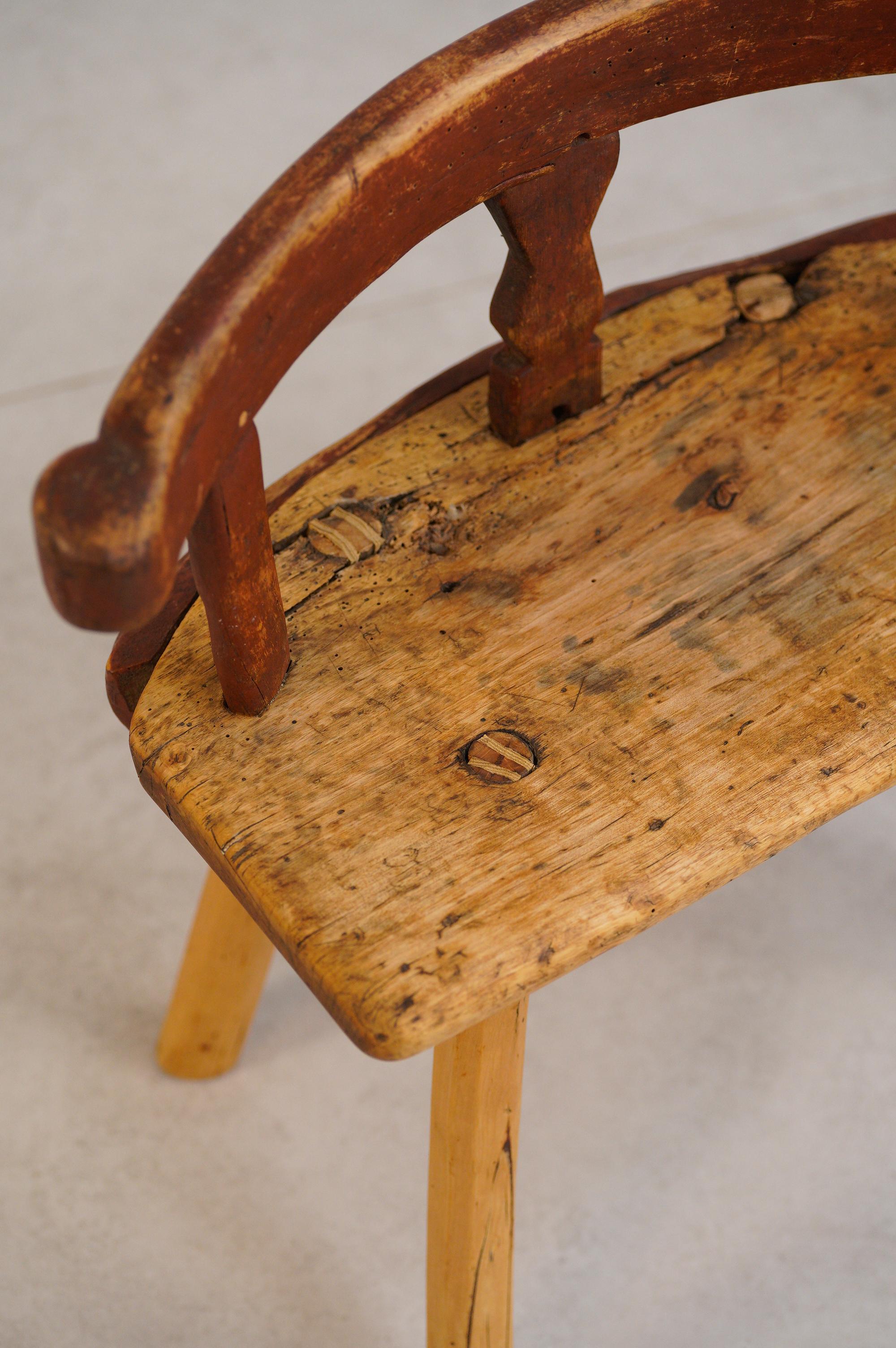 Sculpté à la main au 18e siècle dans du pin en Suède. Ce magnifique tabouret folklorique primitif était utilisé comme tabouret de traite. Le détail du dos est un exemple complexe de l'artisanat folklorique suédois. Les pièces primitives comme