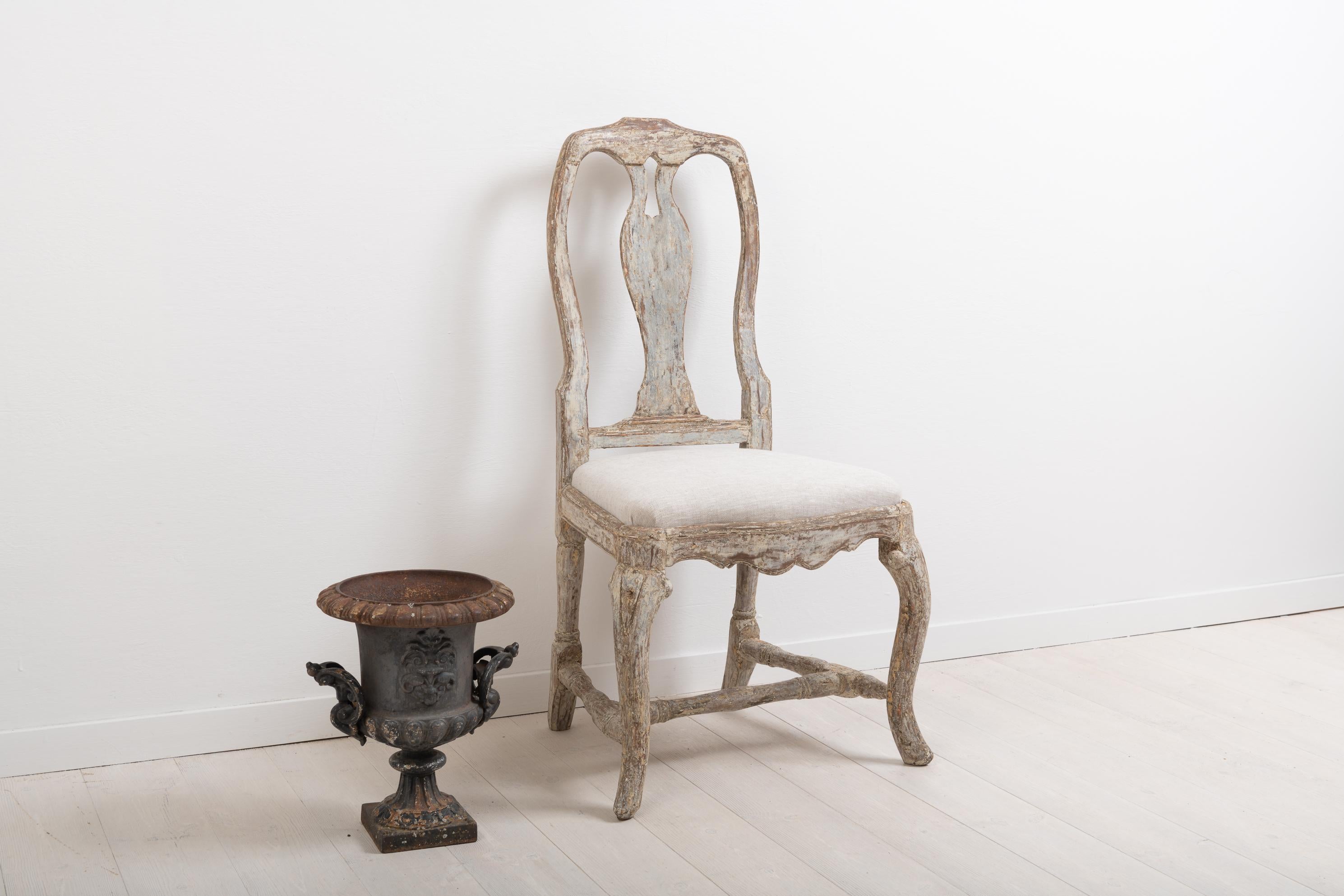 Antique Rococo chair from northern Sweden. The chair was manufactured circa 1770 during the Rococo period. Traces of the original paint with a rustic surface and patina to match. The seat is original and has been renovated with new upholstery in