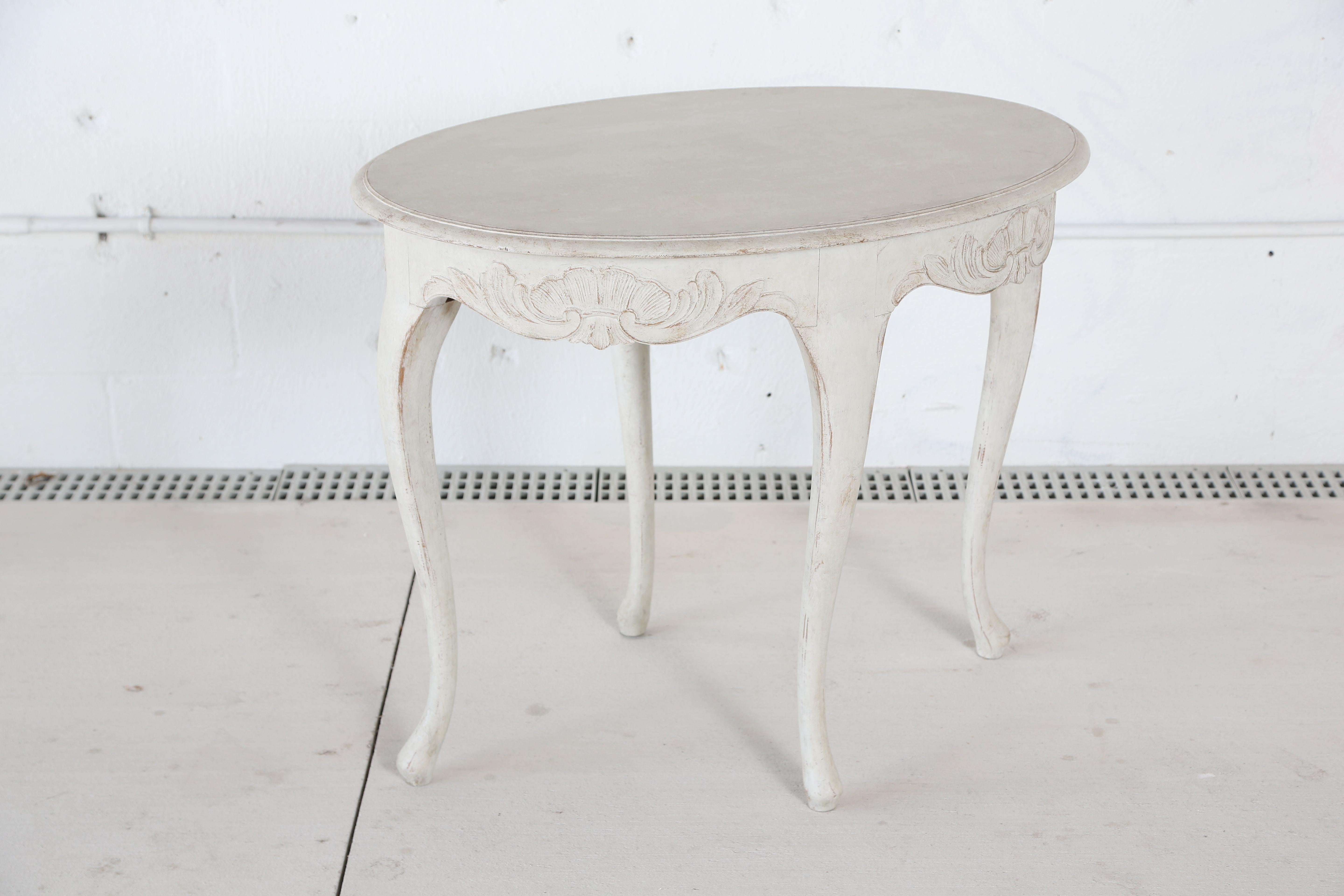Antique Swedish Rococo style painted oval table, painted in Swedish white finish. Lovely scalloped
carved apron with shells and leaves, cabriole legs.

Measures: H 29.50