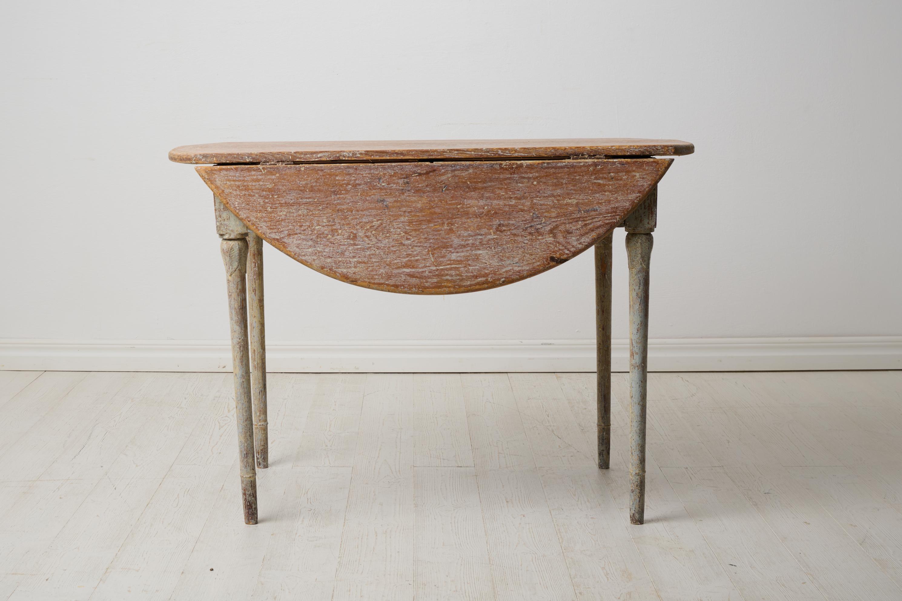 Swedish antique dining table from the gustavian period around 1820. The table is made by hand in solid Swedish pine. Rectangular leg-frame with carved leaves on the two longer sides. Round legs also decorated with carved leaves. 

The table is a