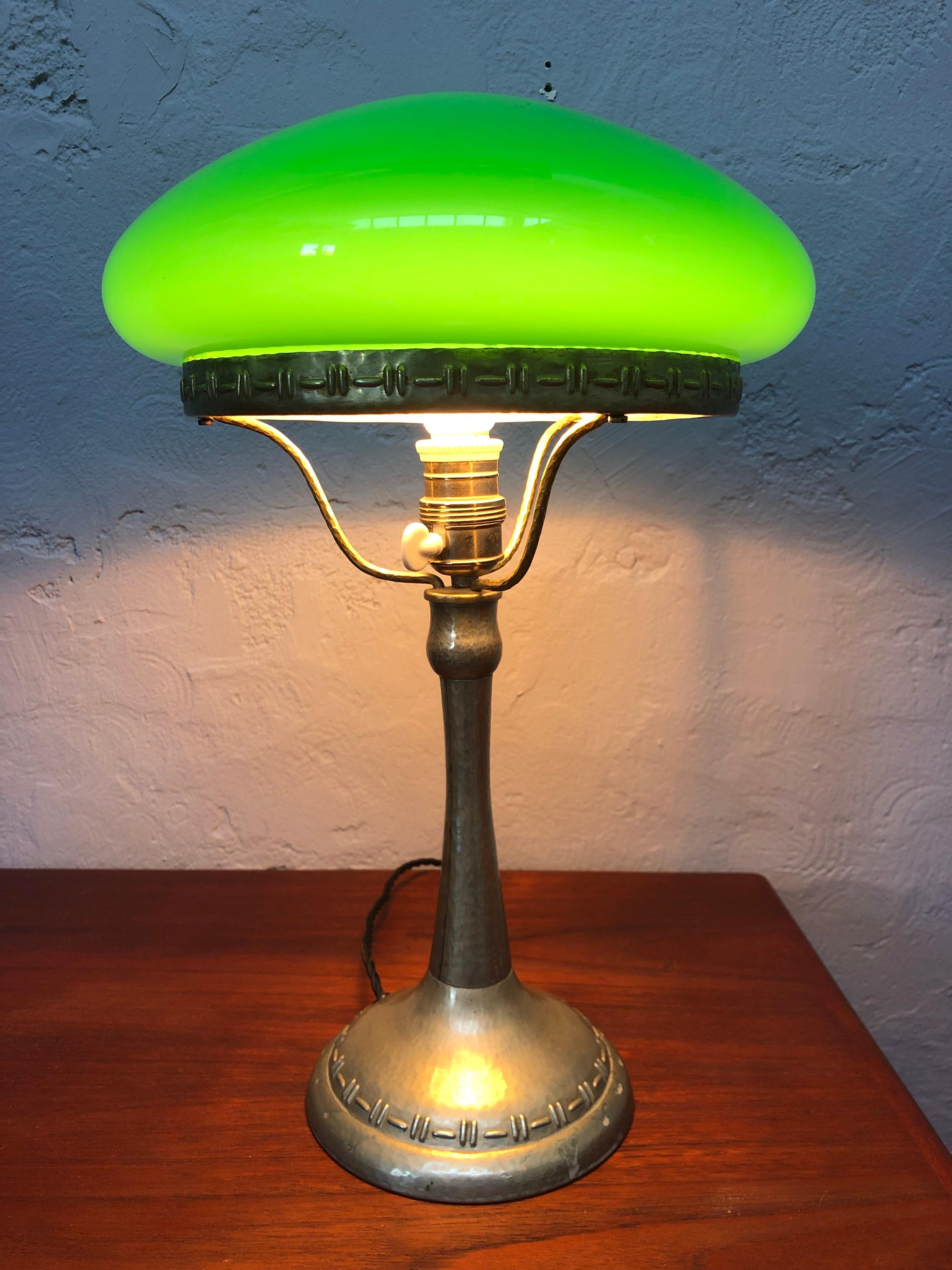 An antique Swedish Strindberg nickel plated silver table lamp from the 1920s.
Hand made panel beaten nickel. 
In original condition and not polished only cleaned. 
Hand blown double layered glass shade. Green on the outside and white on the inside.