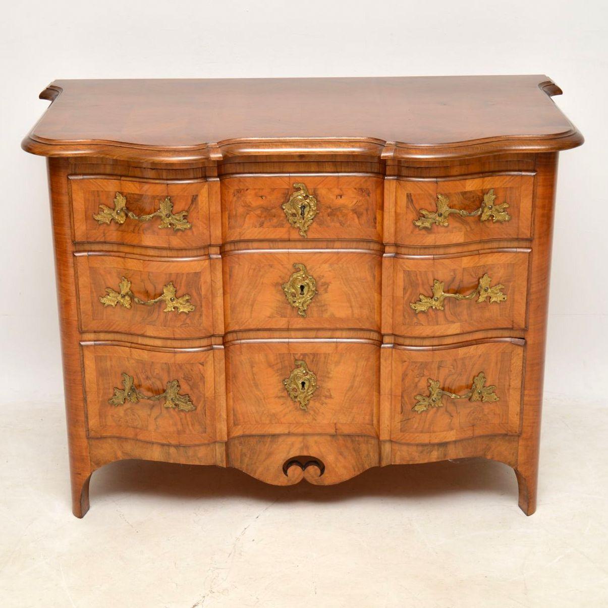 This Swedish antique walnut commode has a lovely shape and is excellent quality. It’s also rare to find these without marble tops. The top and sides are made up with different sections of walnut panels. The front section has an inverted serpentine