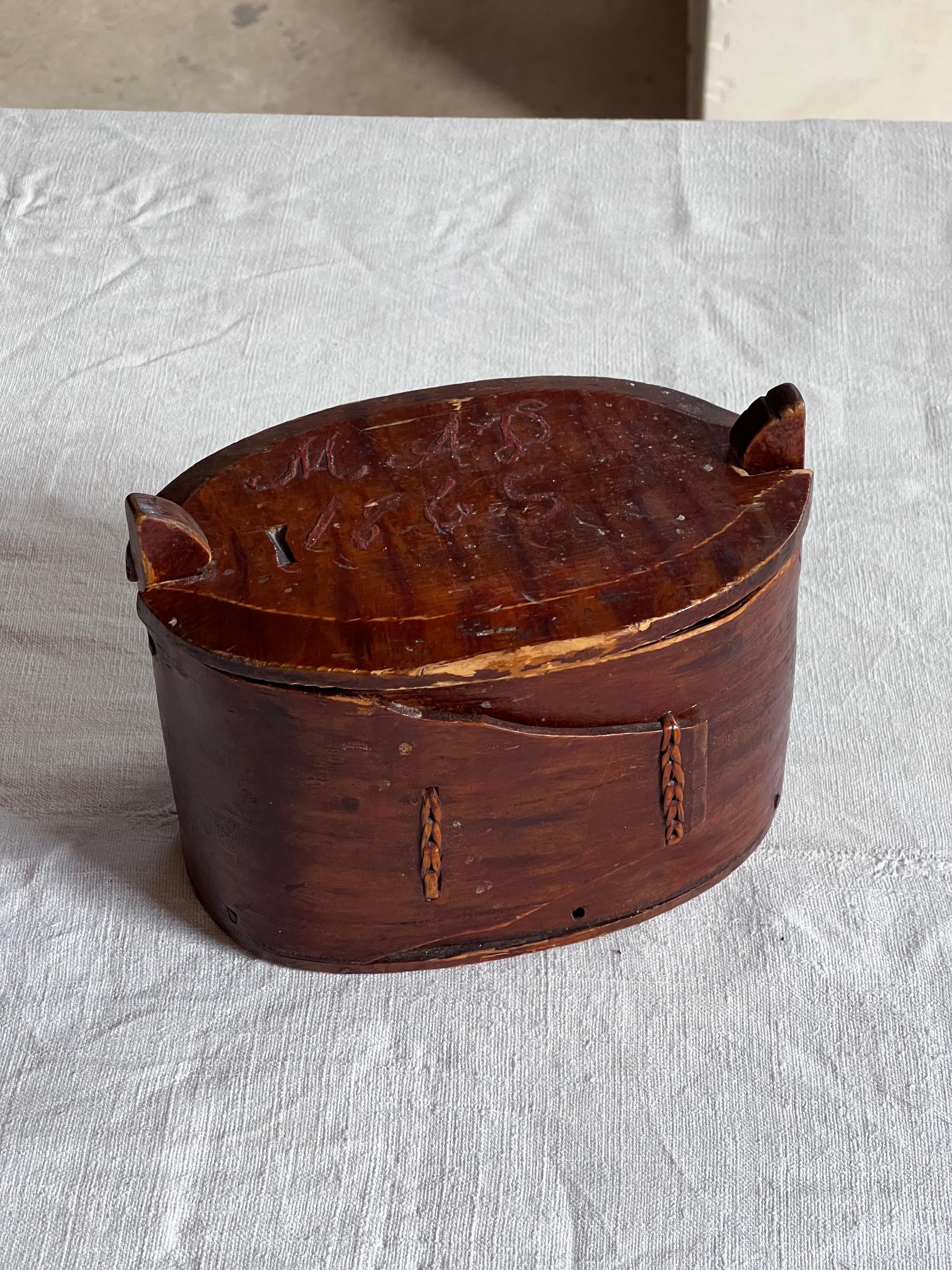 Caja de almacenaje de madera antigua sueca de pino y abedul. . Madera curvada de gran calidad. Es una auténtica pieza del siglo XIX. Las iniciales están pintadas a mano en la parte superior 1865 y grabadas a mano debajo 1896. Bonito complemento en
