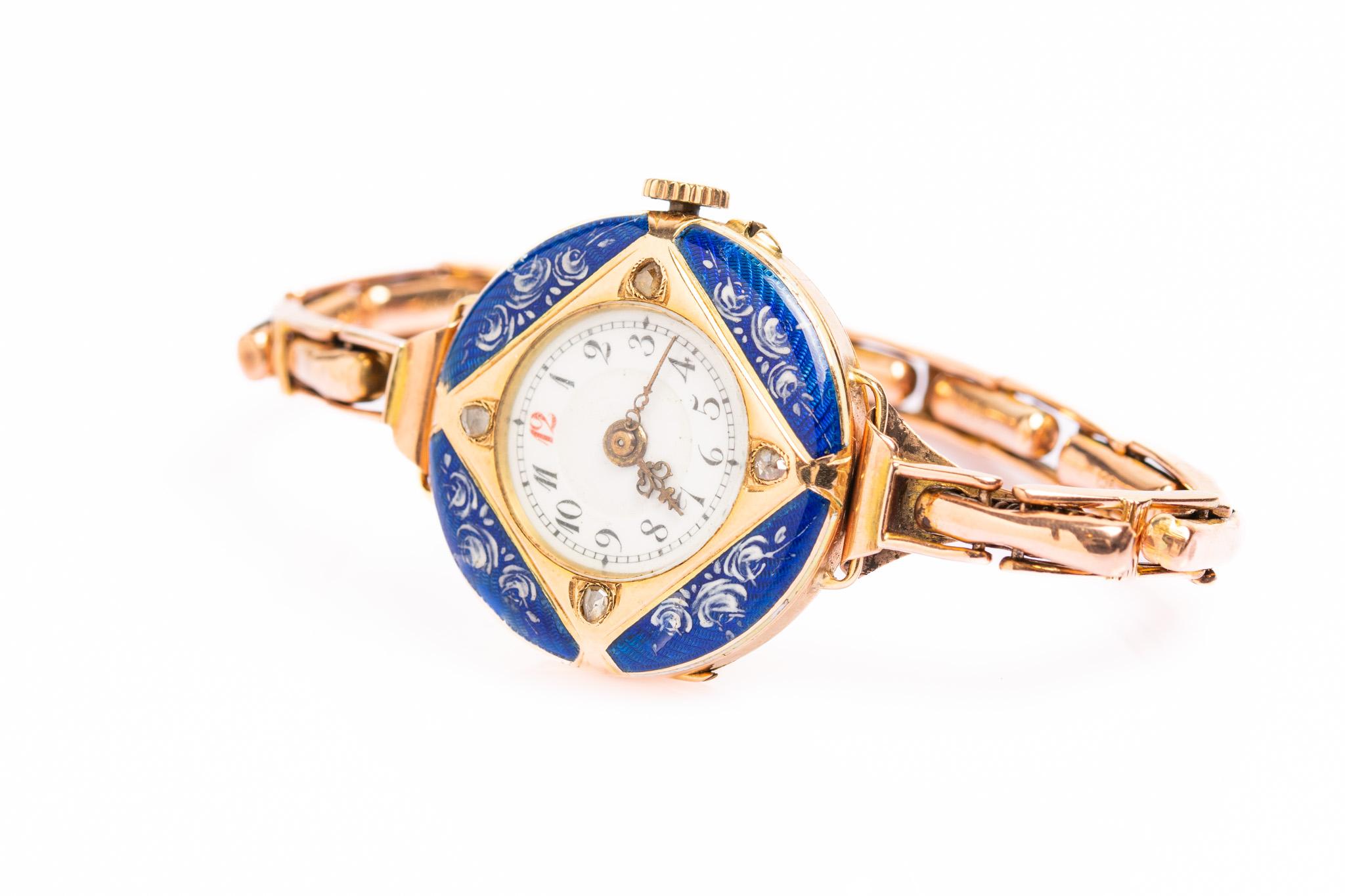 Cette exquise montre-bracelet pour dame en or 14ct, diamants et émail guilloché bleu royal est datée d'environ 1900 et a été fabriquée en Suisse. La montre possède un boîtier rond en or jaune agrémenté d'émail guilloché bleu roi et d'un magnifique