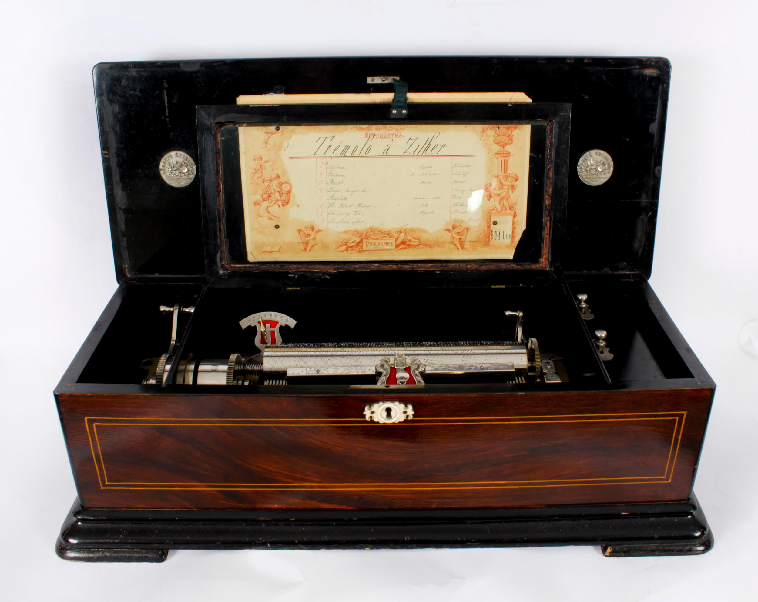 This is  a lovely antique Swiss 8 airs Gonçalo Alves cylinder music box, manufactured by Qualite Excelsior Sondrite Extra Puissant Harmonie, circa 1870 in date. 
 
The Goncalo Alves case is inlaid and crossbanded with boxwood inlay and superb
