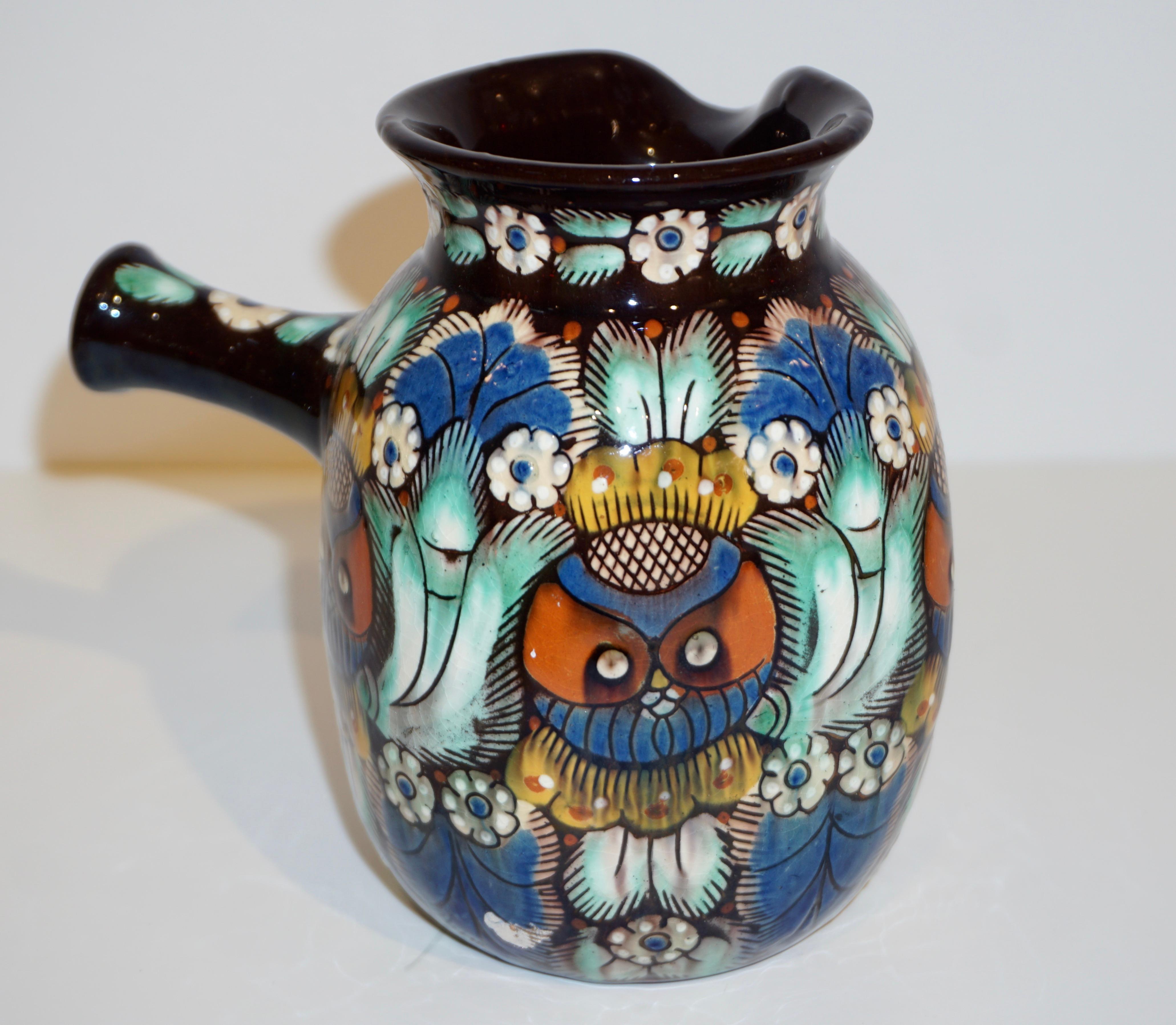 Early 20th century Arts & Crafts Majolica art pottery jug, made by the Swiss factory Thun/Thoune, circa 1910s. This jug, entirely handcrafted and hand-painted, is decorated with a modern Eastern accent design, on black background with vibrant