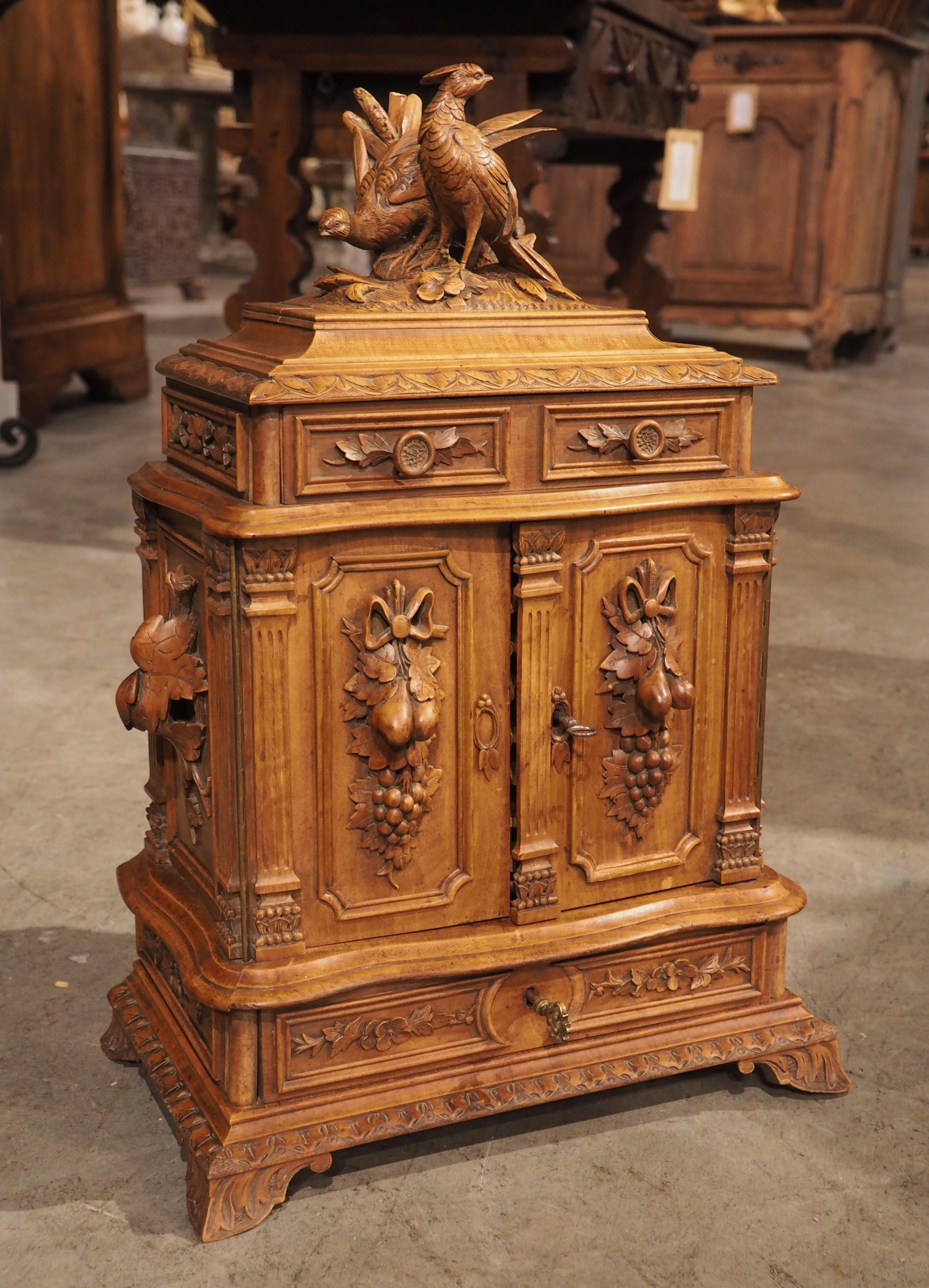 Black Forest accessories are highly sought-after for their inherent beauty and meticulous carvings. This cigar chest was hand-carved in Switzerland, circa 1890, in that lavish style, as noted by the pair of highly plumed birds above a foliate