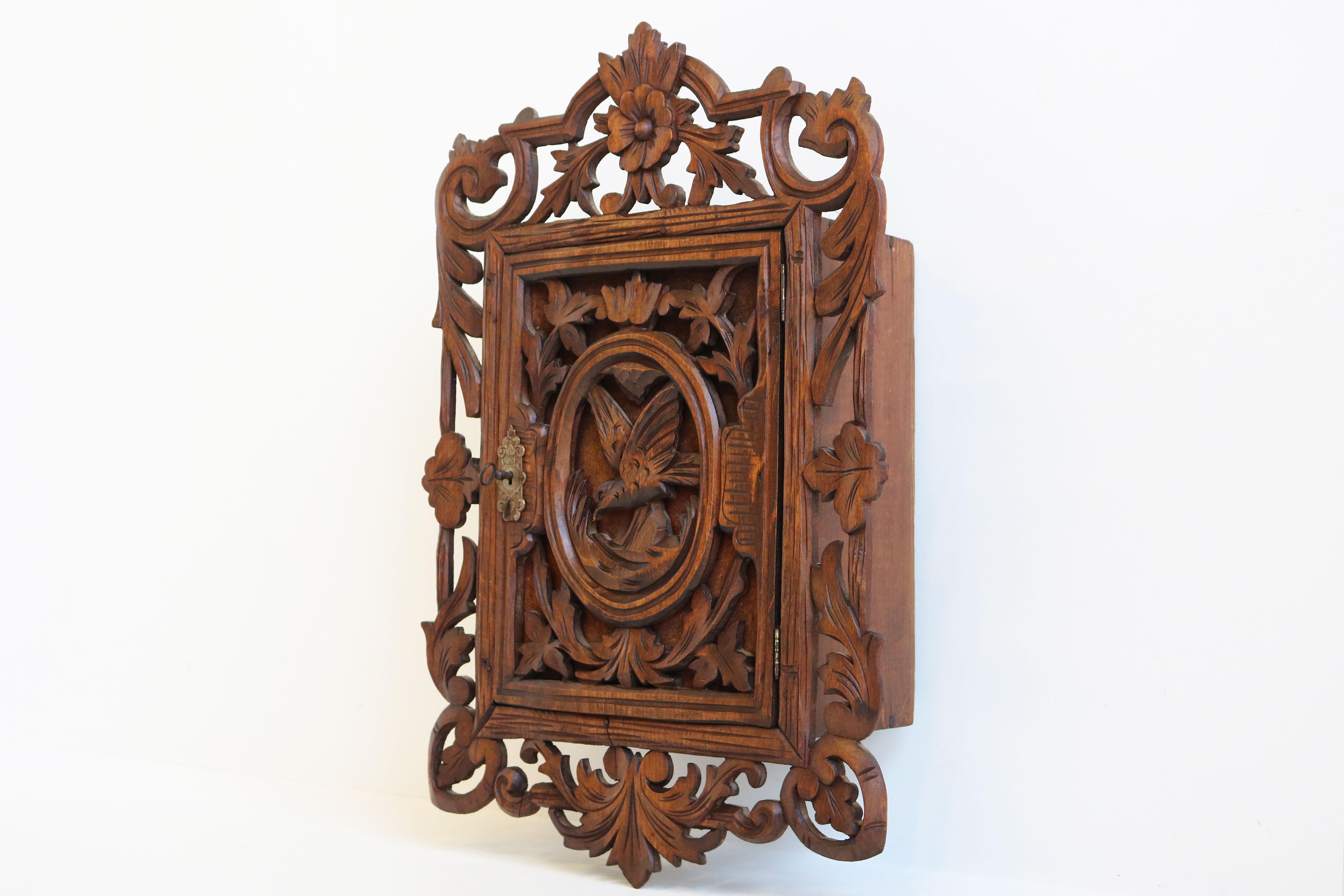 Lovely Swiss 19th century hand carved Black Forest wall cabinet. 
Fully hand carved with gorgeous details & bird in the center in the Black Forest style. 
Made out of solid wood, great quality & craftsmanship. 
Very decorative and practical small