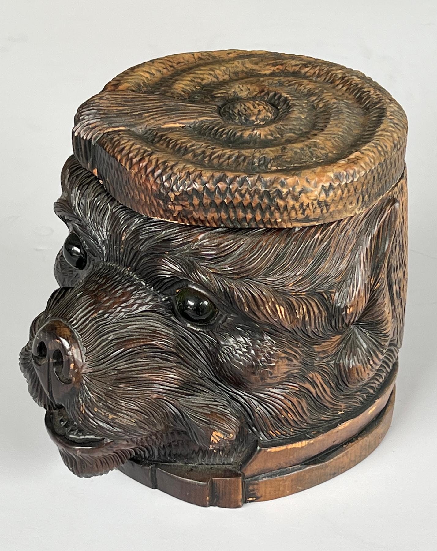 De gran tamaño, la cabeza de un perro bien delineada e intrincadamente tallada con tapa con motivo de sombrero; la cara expresiva con ojos de cristal y gran hocico; muy probablemente de la zona del Black Forest en la ciudad suiza de Interlagen.