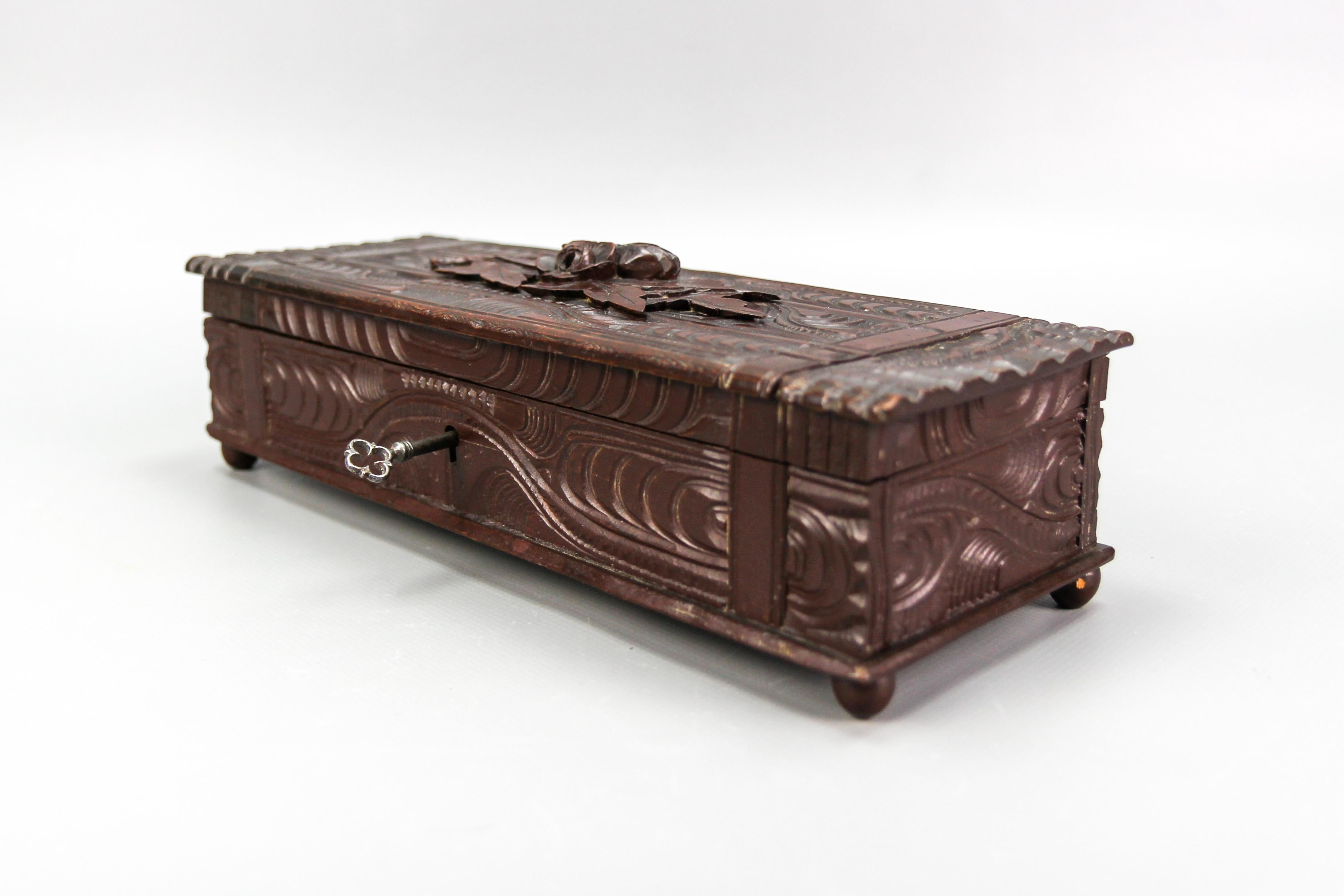 Antique Black Forest dark brown carved wood glove box, ca. 1900
This elegant and beautiful Black Forest style finely hand-carved linden wood glove box from ca. 1900 features a rectangular shape, carved with a wood grain pattern and with flowers and