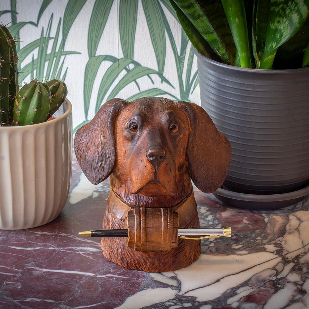 Unusual Pen Tidy Slot

From our Black Forest collection, we are delighted to offer a rare example Antique Swiss Black Forest Dog Inkwell with Pen Store. The Swiss Black Forest Dog is carved from Linden wood and is beautifully executed with a high