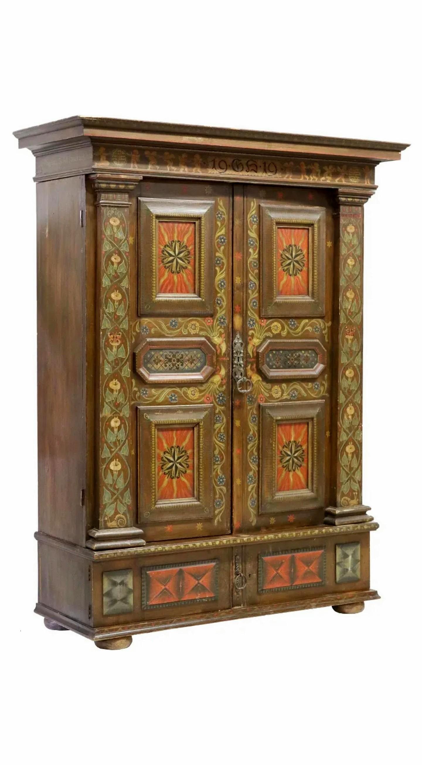 A most impressive rustic country Swiss folk paint-decorated armoire.

Hand-crafted in Switzerland in the 19th century, exquisitely hand-painted with polychrome florals throughout, having molded cornice, crest inscribed 19-GS-19, flanked by winged