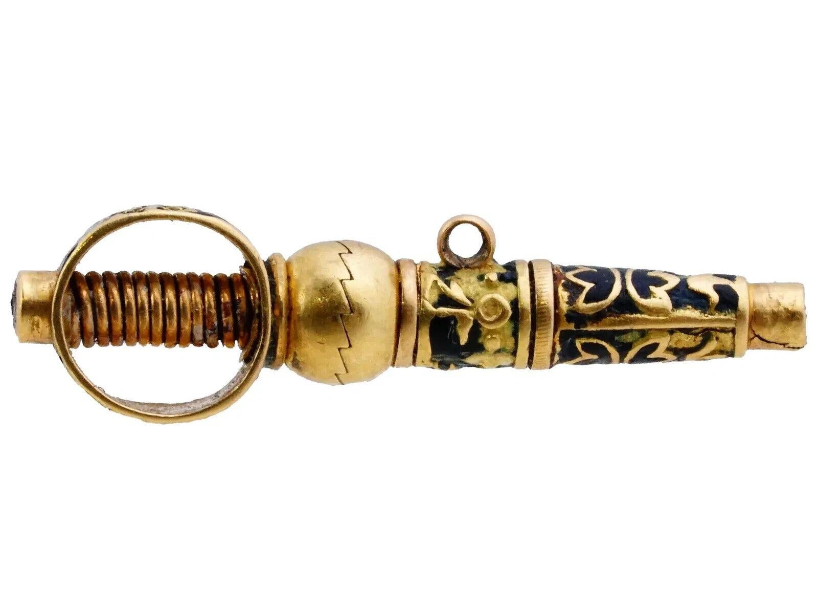 An antique Swiss gold and enamel pocket watch key pendant. The key is richly decorated with floral and foliate patterns. Covered with a dark blue enamel with white accents. It has a ring for hanging. Circa: 19th century. Antique and Vintage Gold