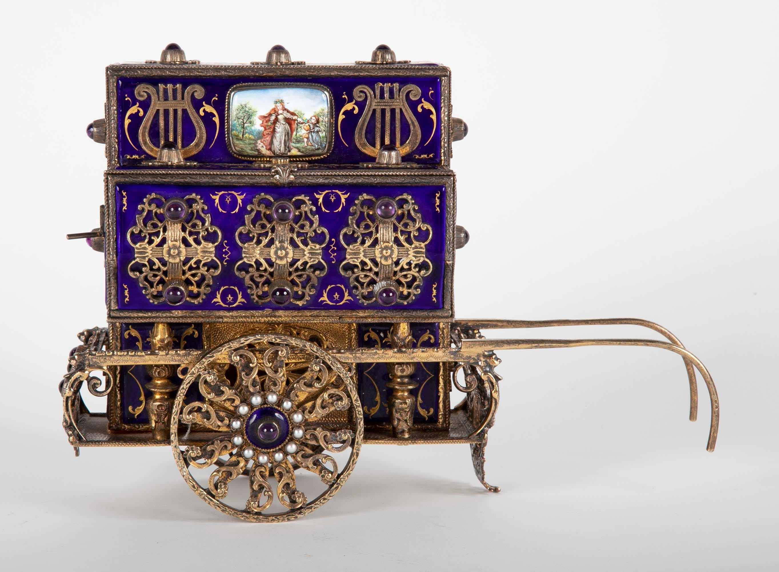 Charles Reuge enamel on sterling silver Swiss antique box in the form of an Organ Grinder's Cart. This piece is one of the rarest of his works using the finest materials including real pearls, sterling silver and cabochon amethyst. Marked Reuge.