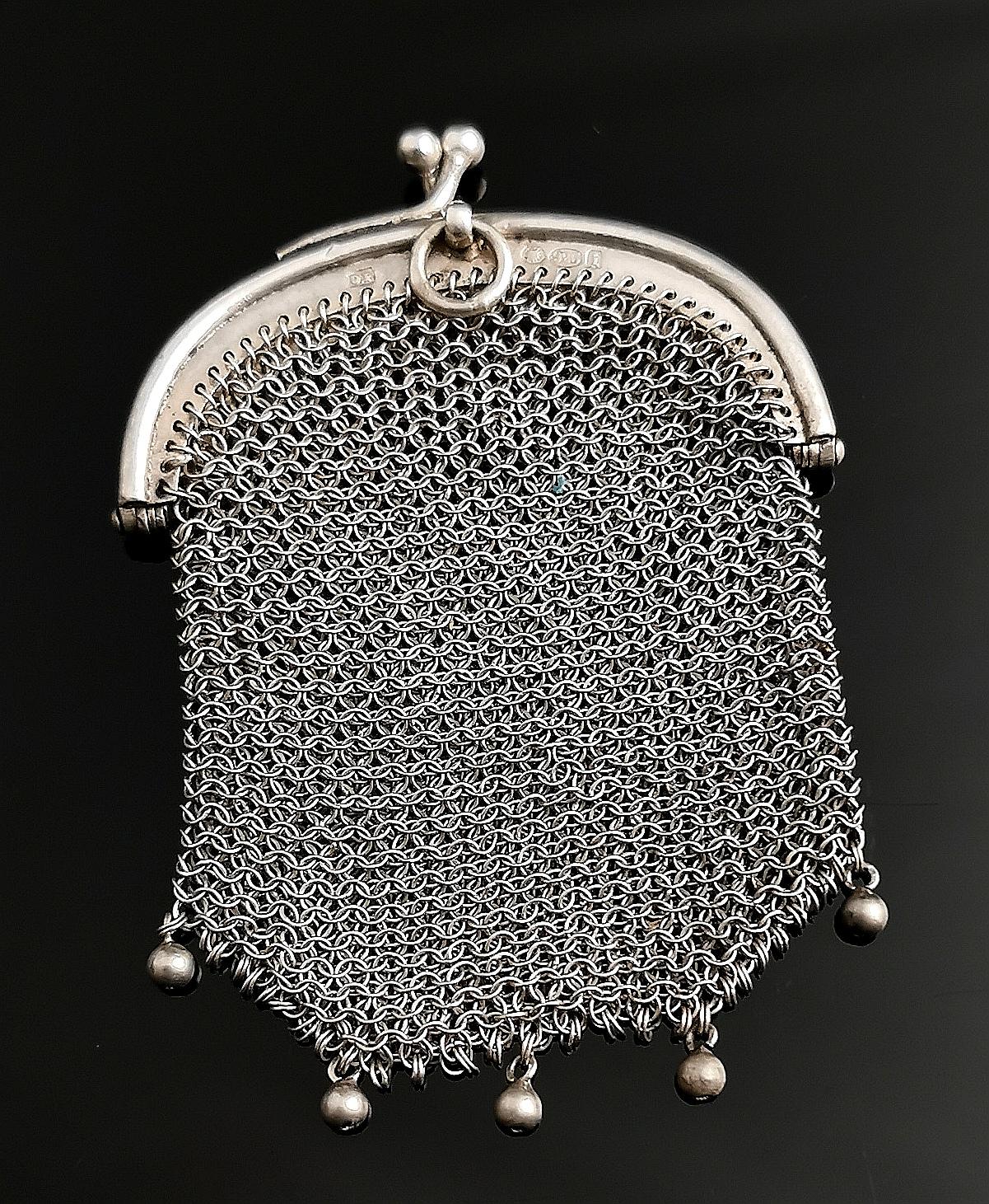A stunning antique Swiss silver chatelaine purse.

The body is made up from intricately woven 925 sterling silver mesh and it has five little beads suspended from the bottom.

The purse has a silver frame with a kiss lock clasp fastener.

There is a