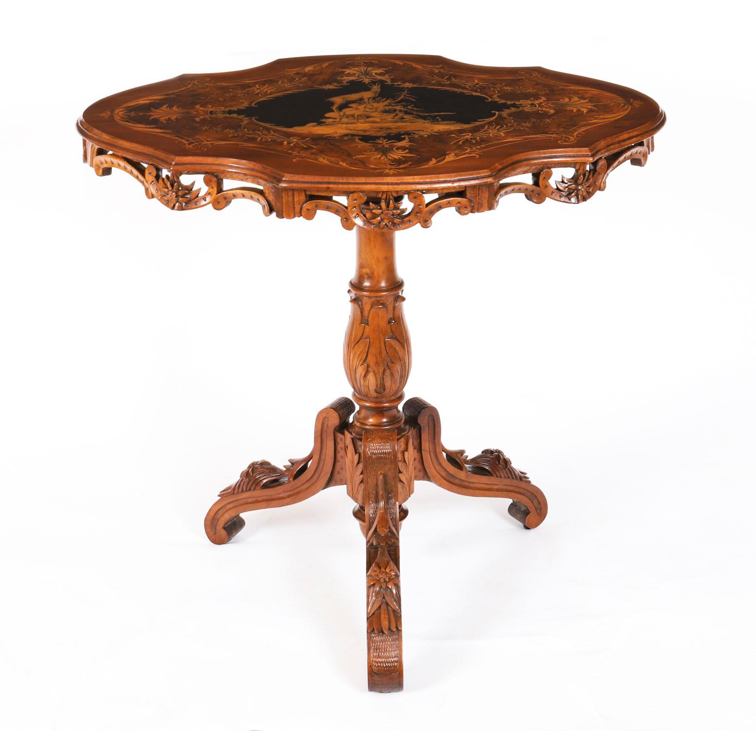 Il s'agit d'une superbe table centrale en noyer suisse sculpté et incrusté de marqueterie, datant d'environ 1870.

Il présente un sommet de forme remarquable, centré par un cartouche décoré d'une chèvre chamoisée au sommet d'une montagne. La table