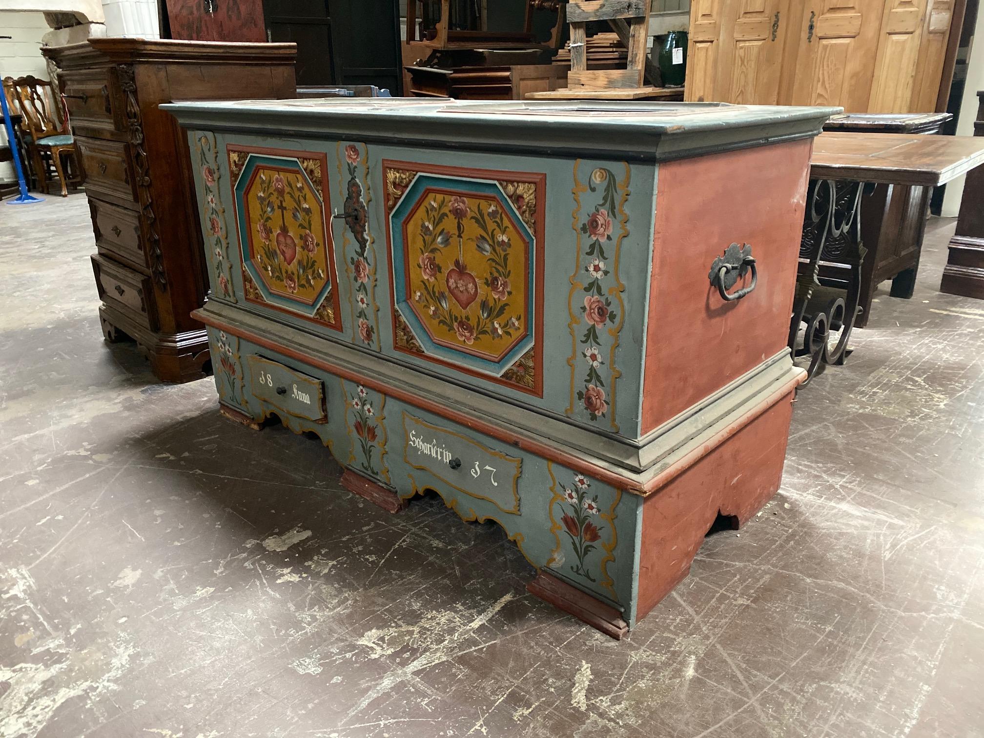 This large, painted chest originates from Switzerland, circa 1830s. It features a vibrant design and well preserved interior with drawers and pockets.

Measurements: 27