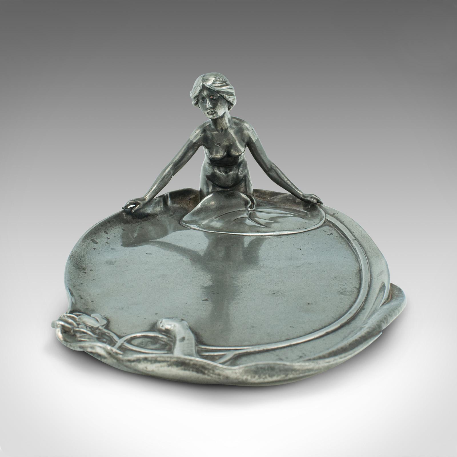 This is an antique table centrepiece. A German, pewter 'lady of the lake' decorative tray, dating to the early 20th century, circa 1920.

Wonderful nymph iconography with Art Nouveau overtones
Displays a desirable aged patina and in good original