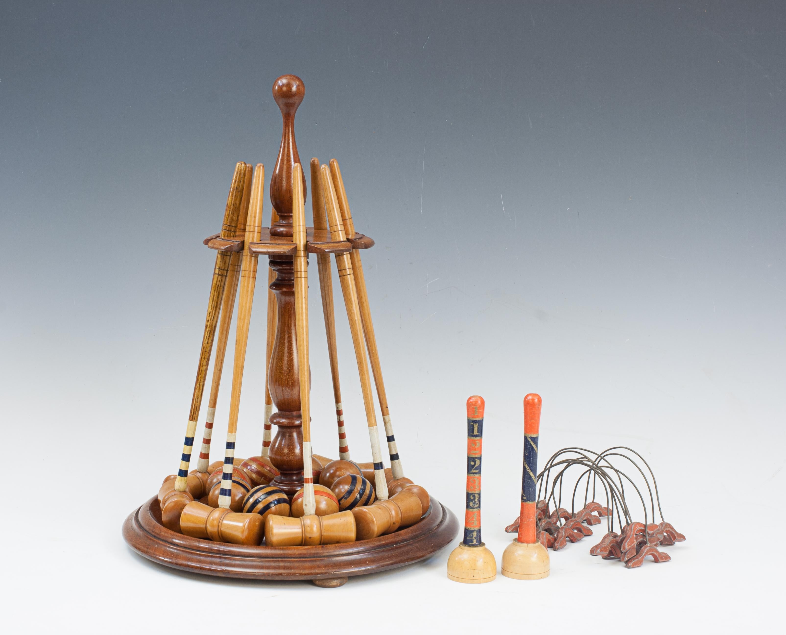 Original Table Top Miniature Croquet Set.
An original parlour game of miniature croquet displayed on it's original mahogany stand and complete with all the fittings for a table. The set contains 8 boxwood mallets, each having a coloured band of red