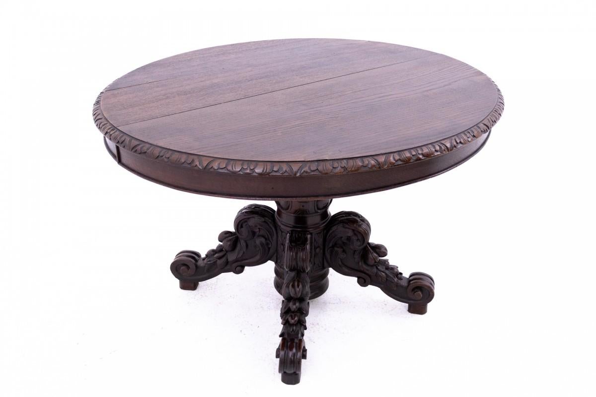 Table ovale du milieu du 19e siècle dans le style Renaissance.

Un meuble ancien dont le plateau est décoré de sculptures repose sur un meuble massif.

un piédestal lourdement sculpté. L'ensemble a une allure digne et ancienne. Très bon