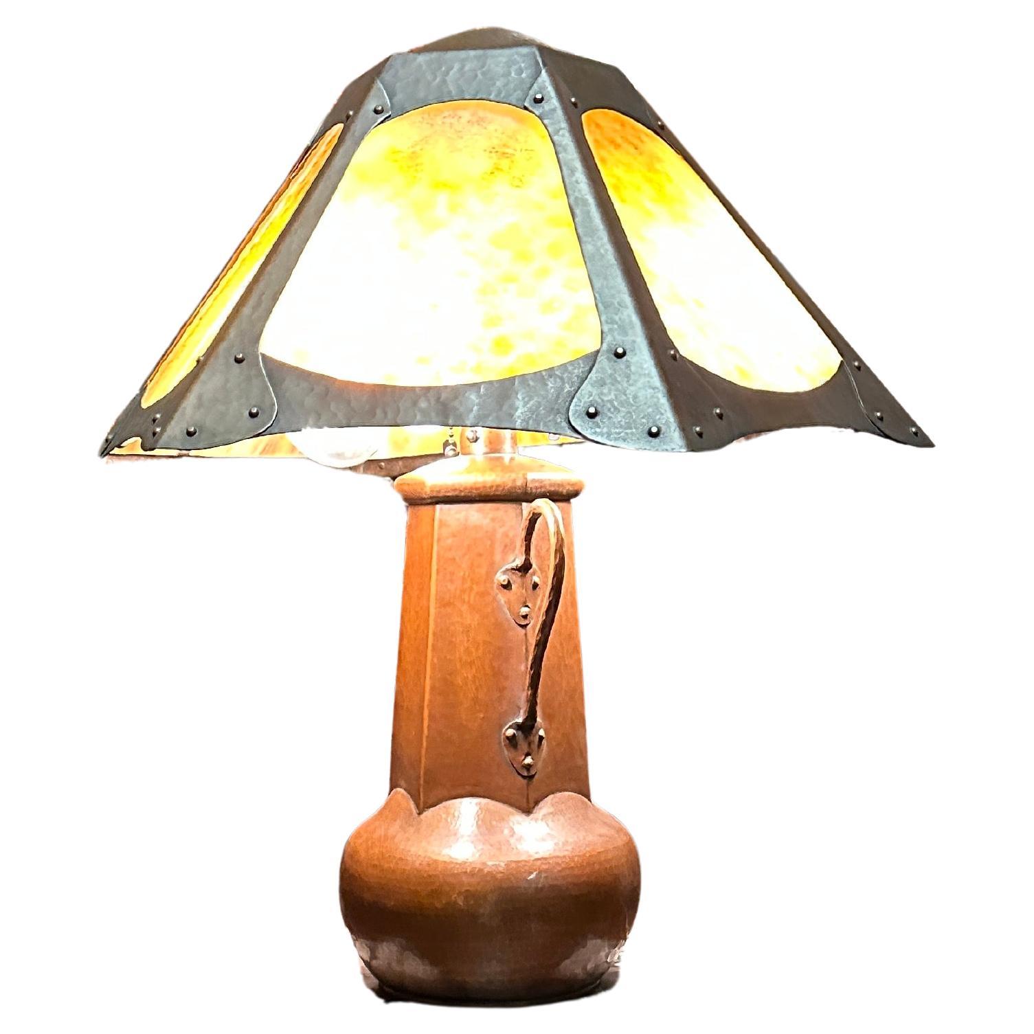 This is an Arts & Crafts Limbert Table Lamp from the early 1900s.  It has the original patina on the metal parts of the shade.  Also in the shade, the glass is authentic period Kokomo Catspaw Opalescent Glass made circa 1890 by the the Opalescent