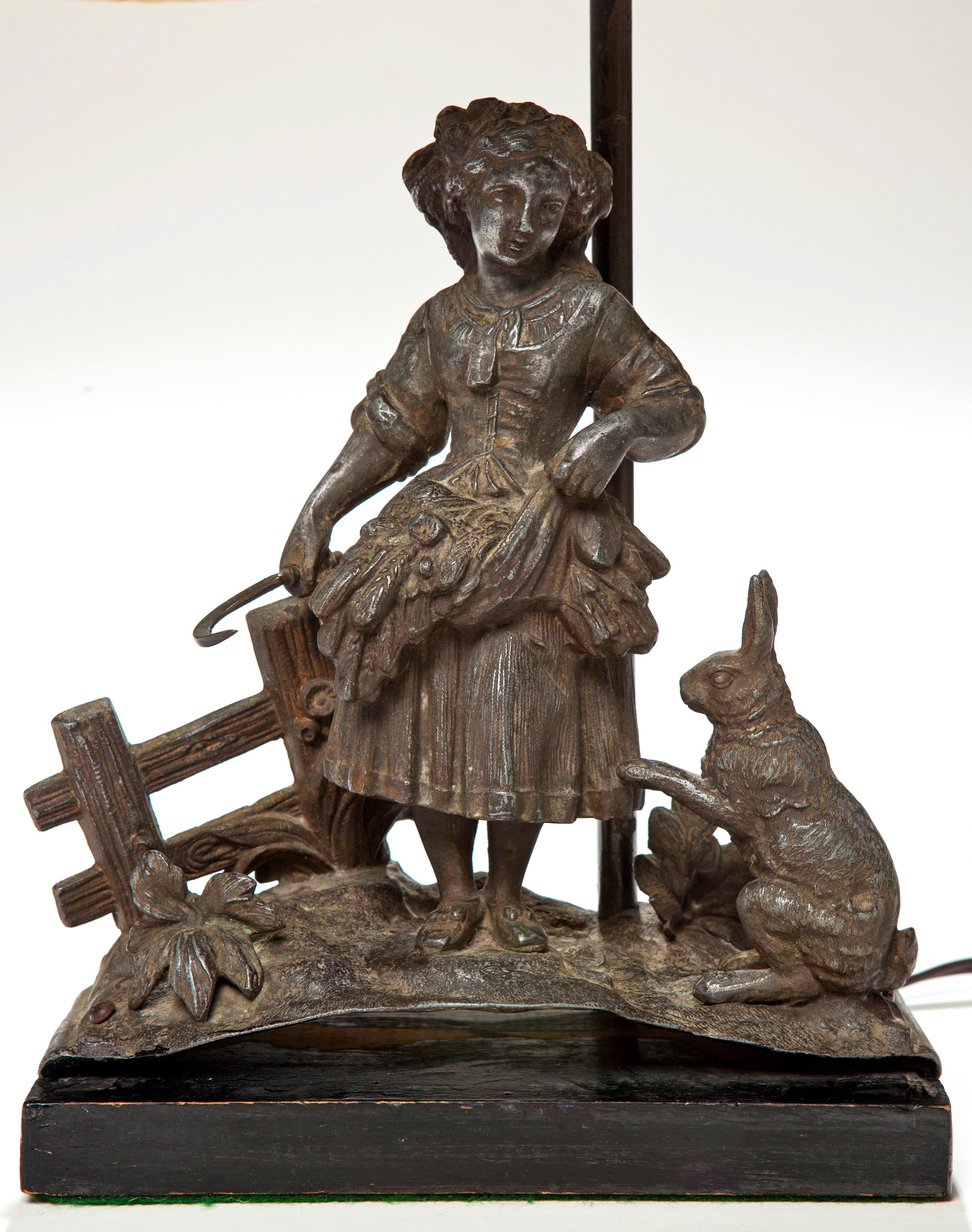 Adorable antique lamp of a young girl holding a basket of wheat with a sickle and a bunny rabbit sitting next to her. Super special and most likely this was an early sculpture that was made into a lamp. Metal has a washed steel look to it, with