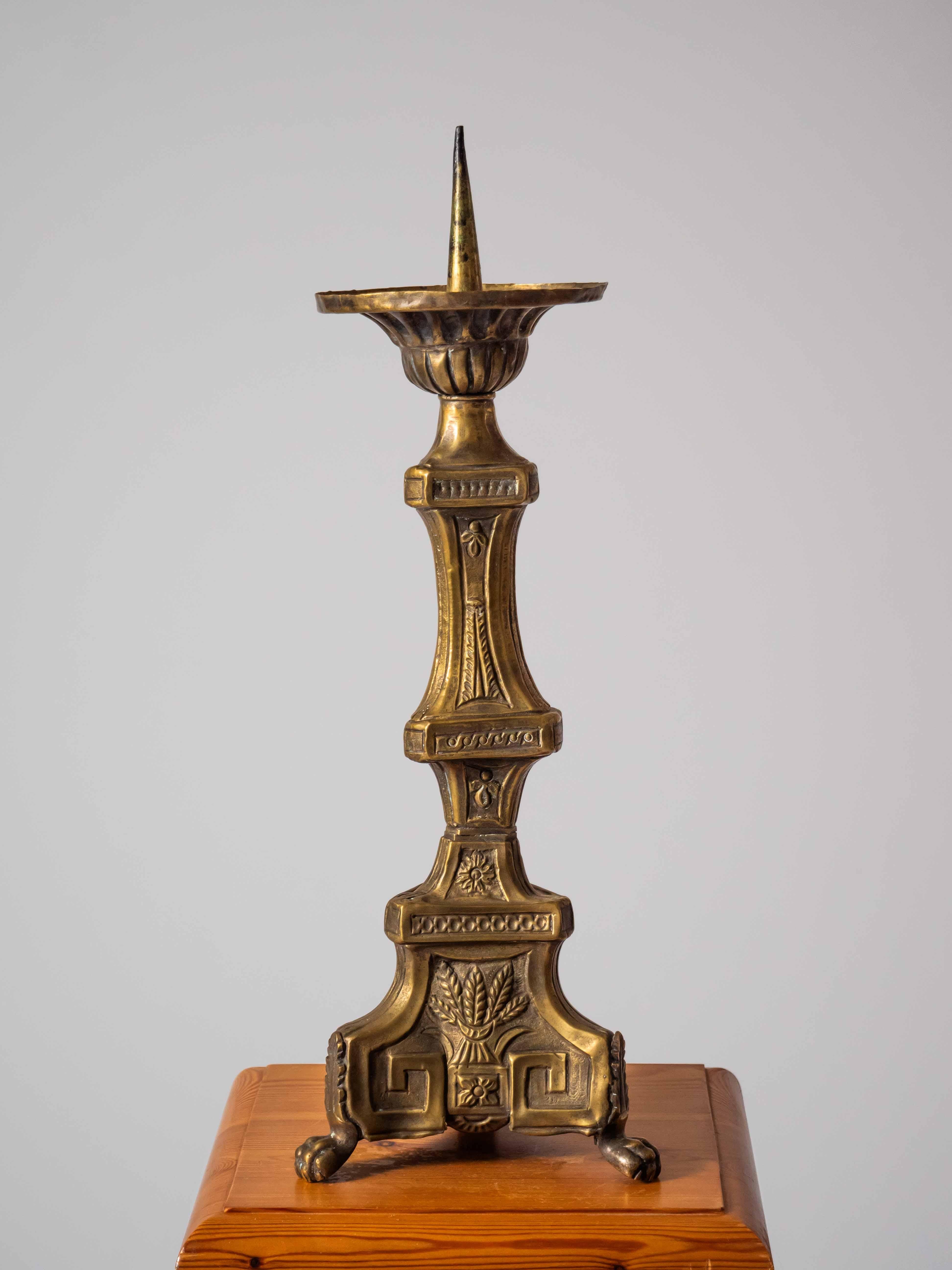 Antique table lamp on paws in 45 cm

Antique wrought brass sheet candle holder. Handmade from the end of the 19th century. The candlestick is decorated with a motif of a bundle of straw with ears of corn. The candlestick has a zoomorphic end with