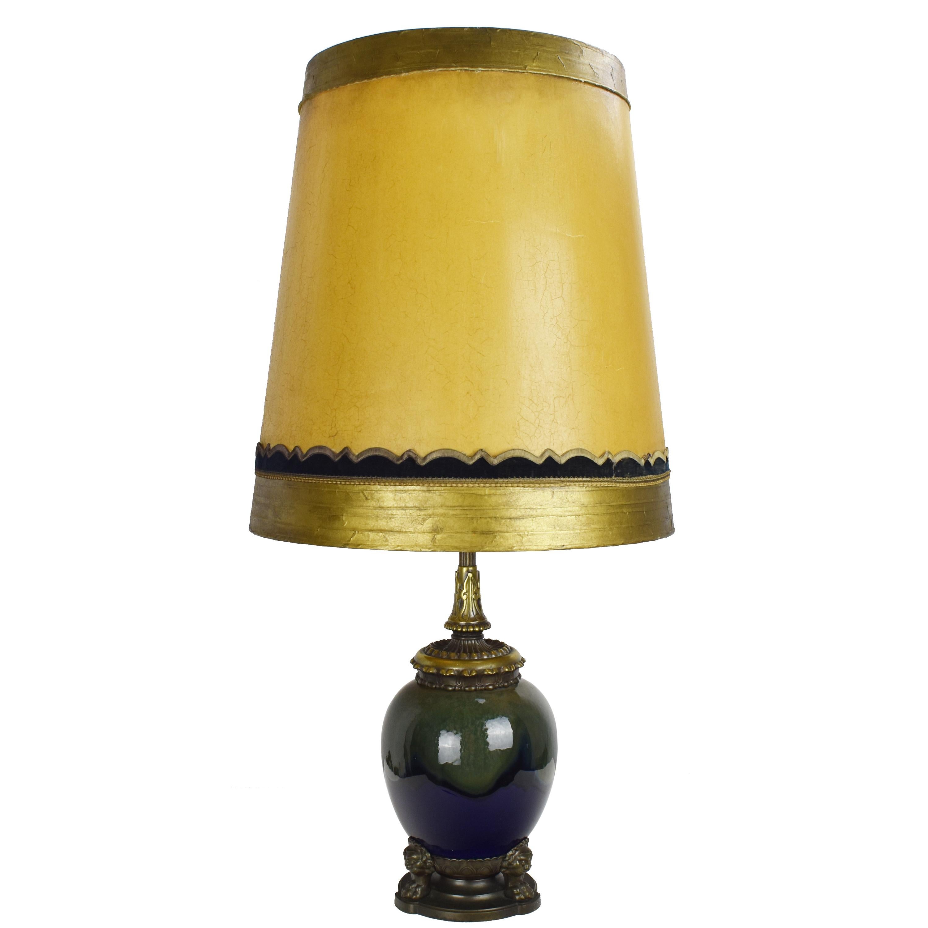 This antique table lamp with a solid bronze mount from Rosenthal dates back to around 1910. The porcelain body, reminiscent of a Chinese ginger jar, featuring a stunning runny glaze in dark green tones over a cobalt blue background. 
The mount,