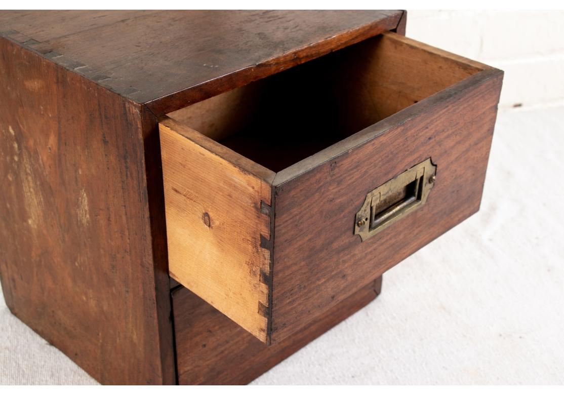 Da una collezione nautica di Essex, Connecticut. Antica cassettiera da tavolo Campaigner con due cassetti. Costruzione con incastro a coda di rondine e due maniglie a coda di rondine in ottone.
 
Condizioni: Si prega di vedere le foto dei dettagli.
