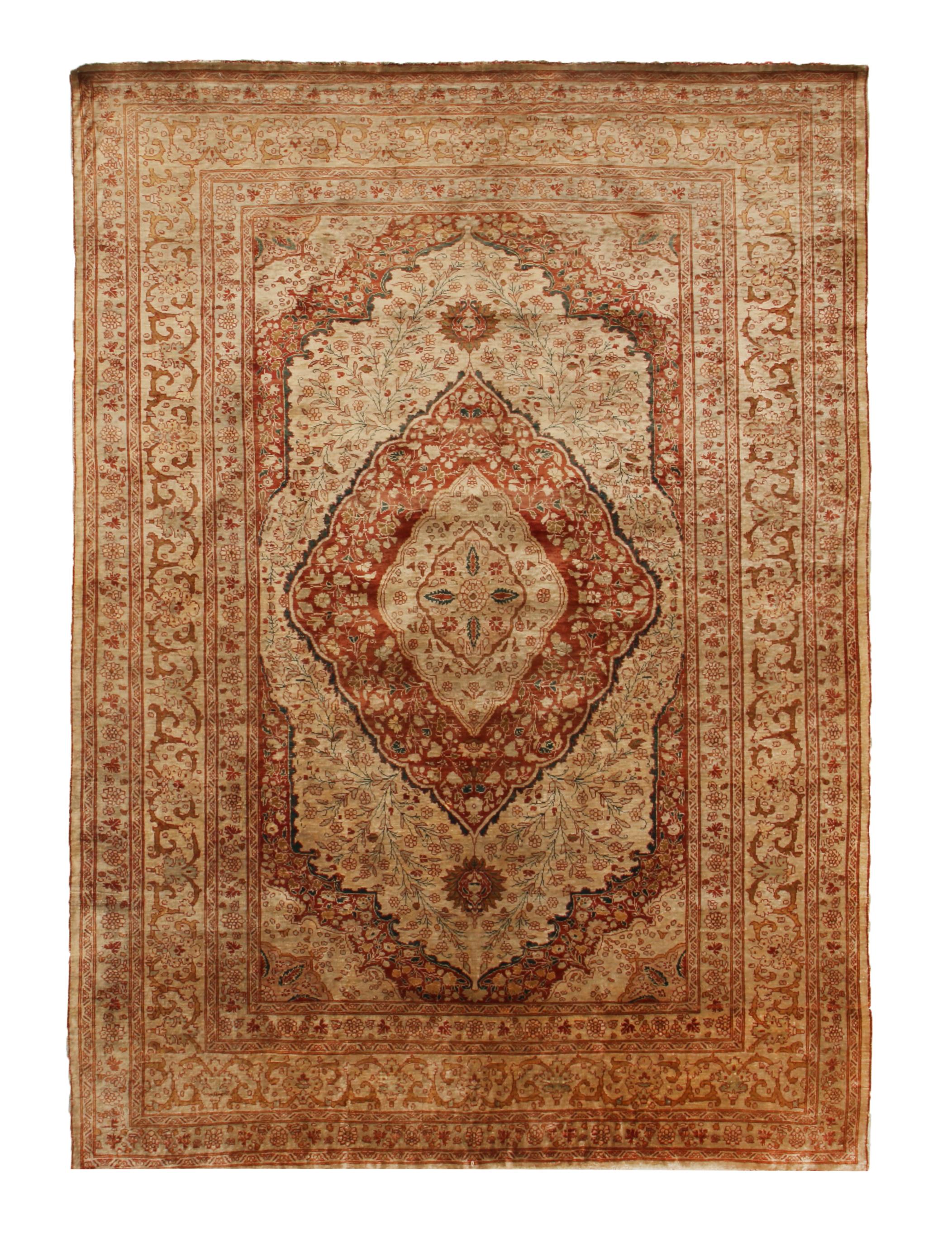 Hand knotted in a lightly distressed, luminous silk body originating from Persia in 1900, this antique Tabriz Persian rug enjoys an uncommon dimensionality in the pairing of these rare beige and pink colourways with an intricate field and border