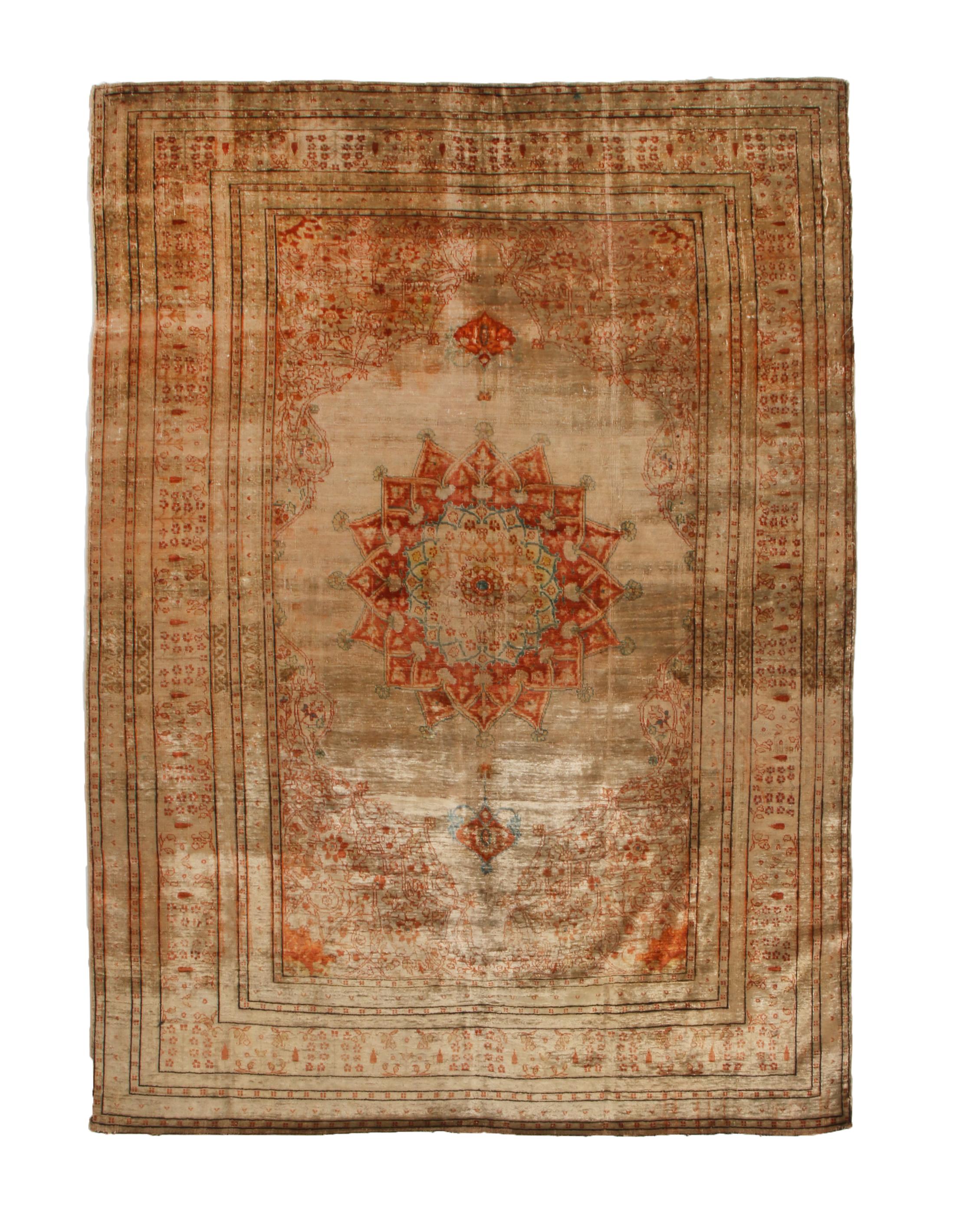 Originating from Persia in 1910, this antique Tabriz Persian rug is hand knotted with a soft, quality wool pile married to some of the most distinguished muted and vibrant colourways. Featuring a medallion style field design in elevated brown and