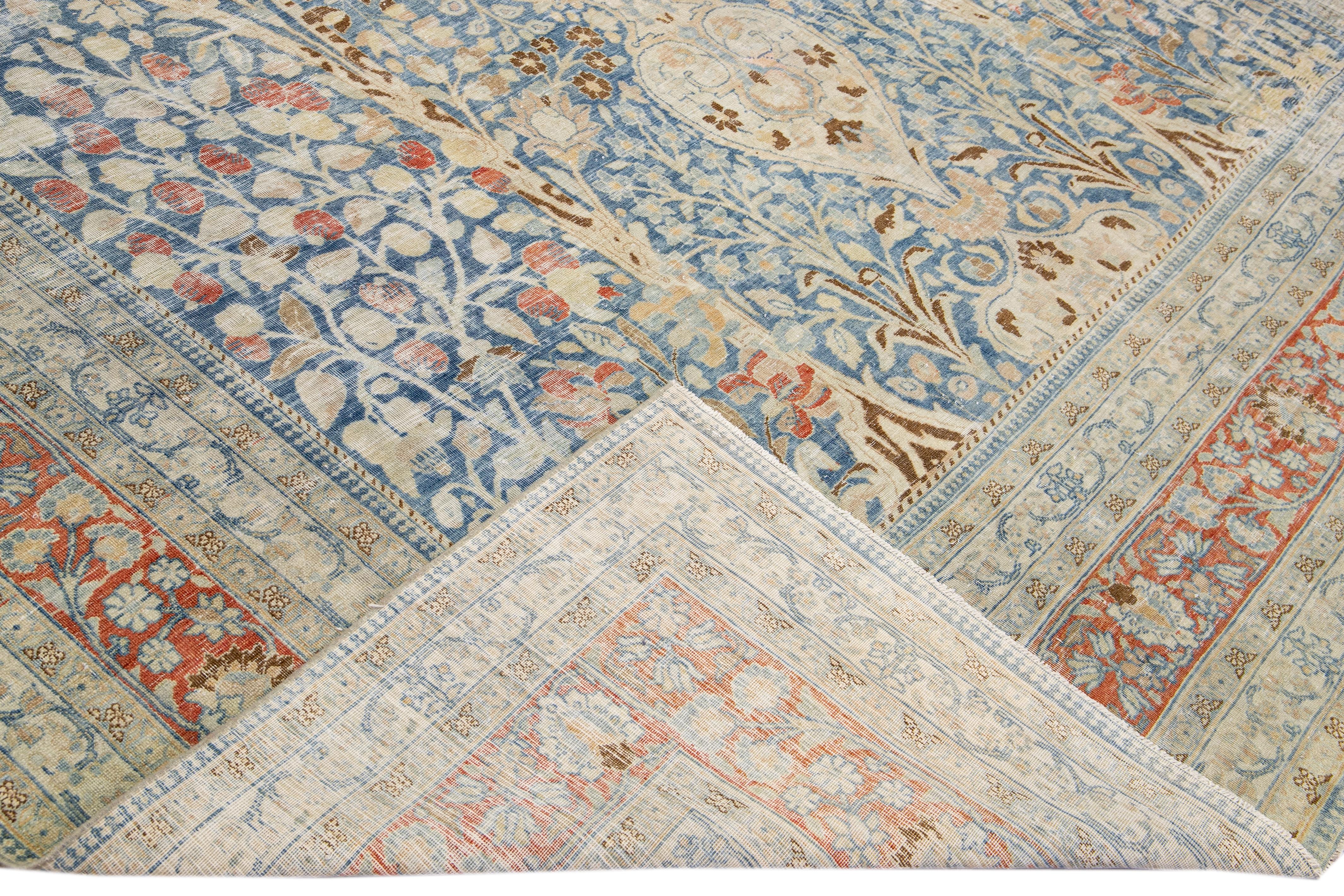 Beautiful antique Tabriz hand-knotted wool rug with the blue field. This Persian piece has a rusted designed frame and beige accents traditional in all-over floral design. 

This rug measures: 10'3