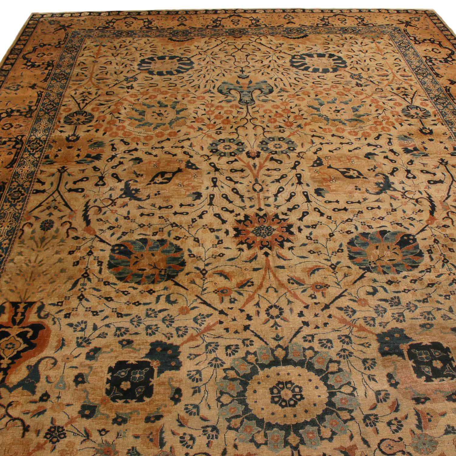 Hand knotted in high-quality wool originating from India in 1910, this antique Tabriz rug embraces several transitional design elements with an uncommon vertical symmetry to its field design. Emboldened by ornate golden-brown floral ornaments with