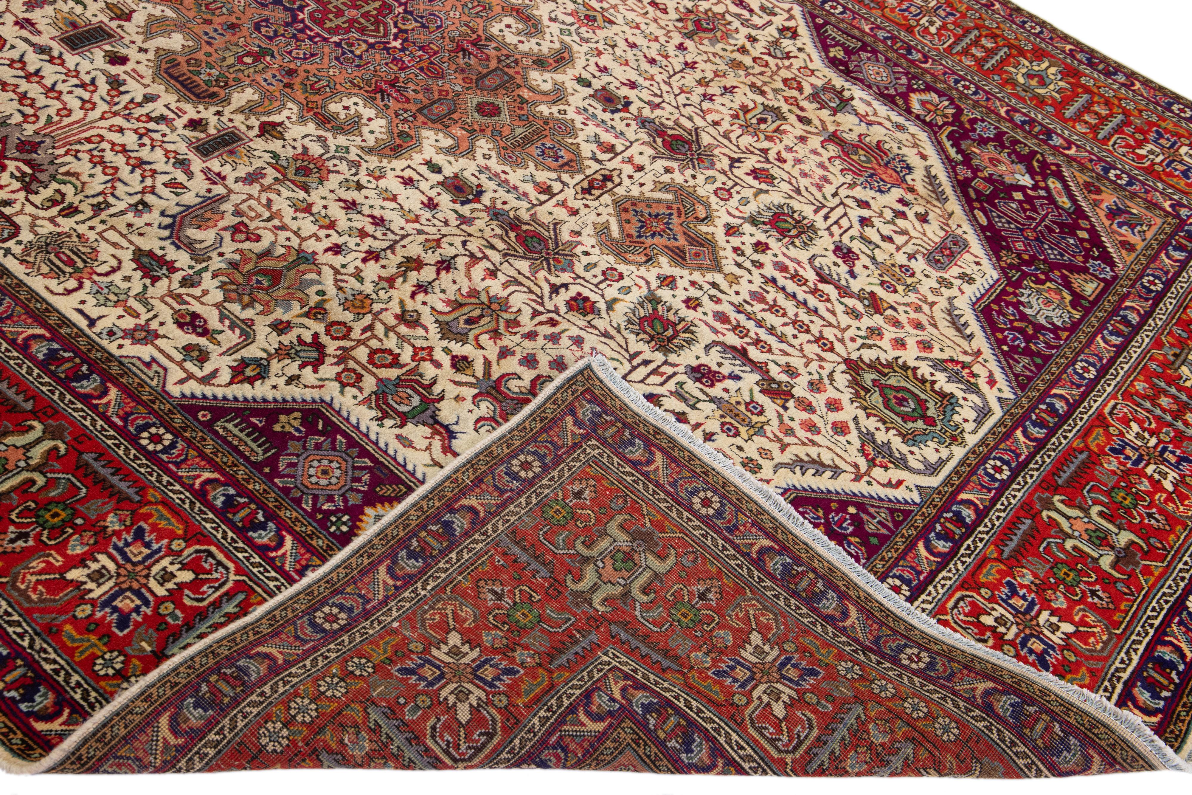 Beautiful antique Tabriz hand-knotted wool rug with beige and burgundy field. This Persian piece has a red frame and multicolor accents in an all-over Shab Abbasi design. 

This rug measures: 8' x 11'2