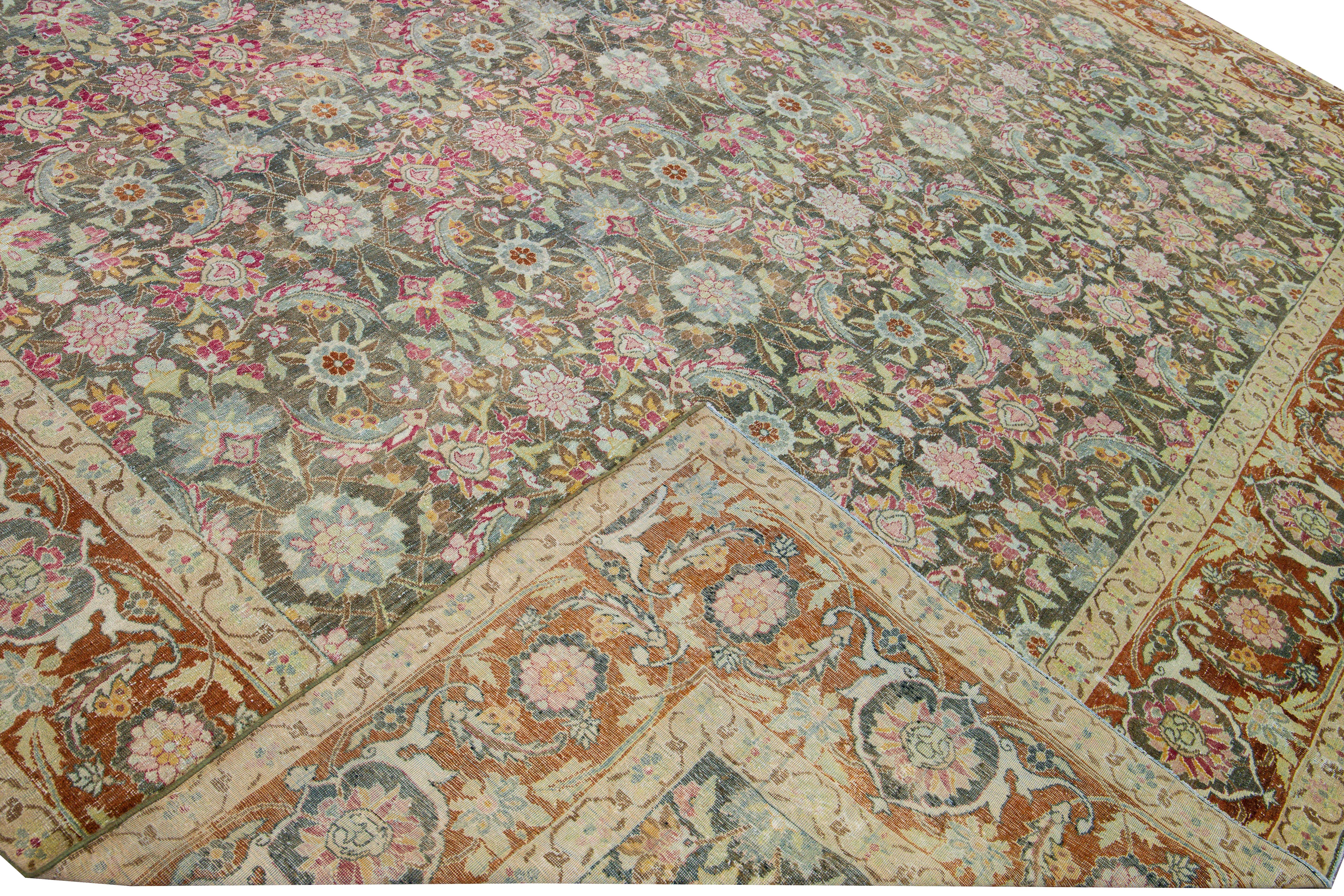 Beautiful antique Tabriz hand-knotted wool rug with a gray field. This Persian piece has a rusted frame and multicolor accents that feature an all-over botanical pattern design.

This rug measures: 11'2