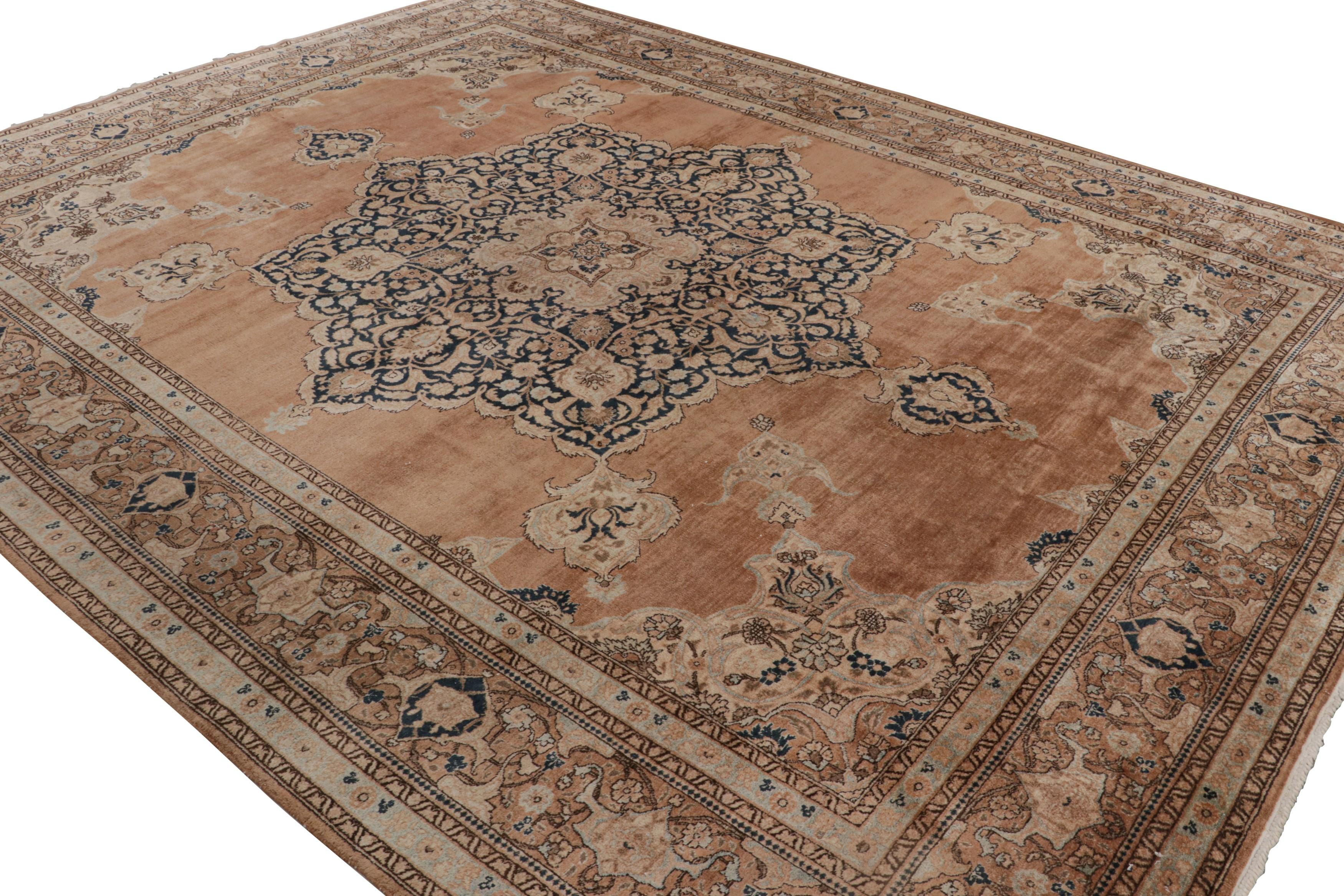 Annodato a mano in lana e proveniente dalla Persia intorno al 1910-1920, questo tappeto antico 10x13 presenta un disegno Tabriz con un distinto motivo a medaglione e colori beige e oro in buone condizioni.