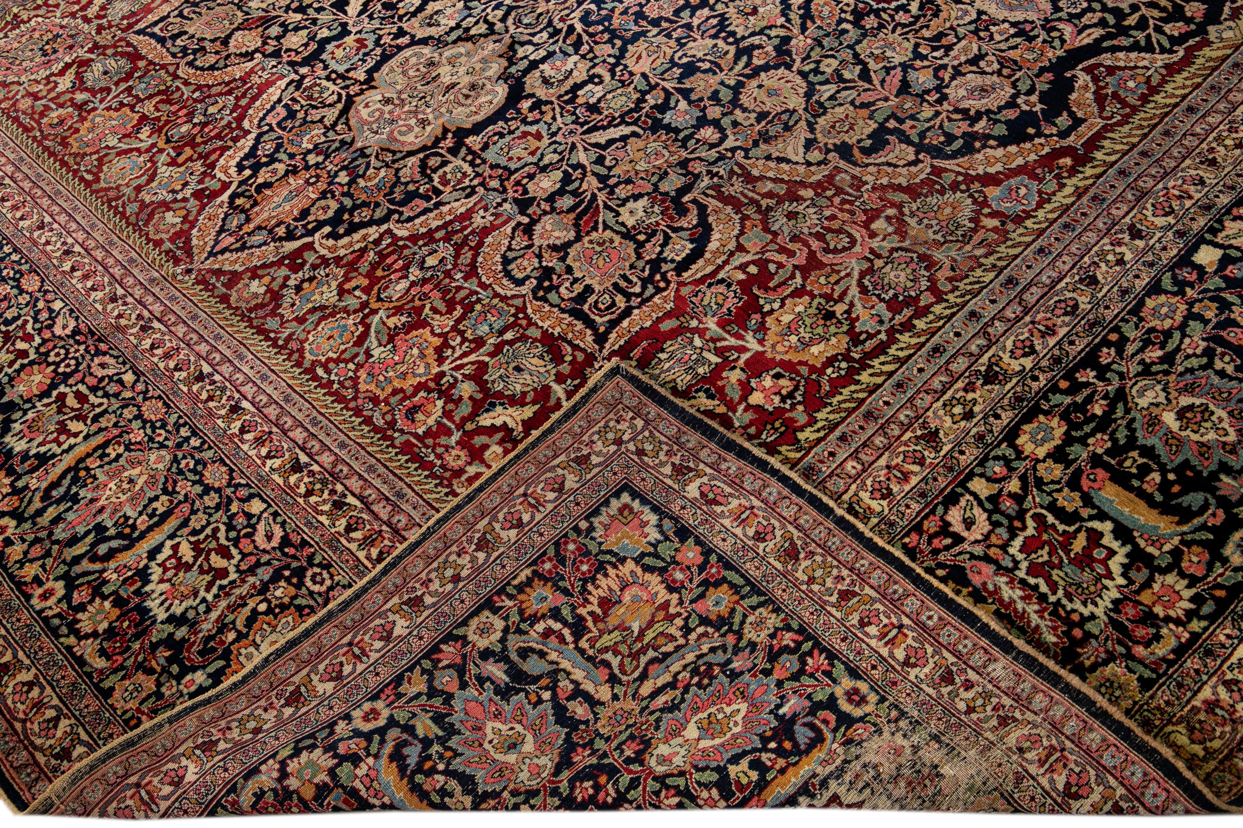 Beautiful antique tabriz hand-knotted wool rug with a red field. This Persian rug has a navy blue frame and multicolor accents in a gorgeous all-over geometric medallion floral motif.

This rug measures: 11'10